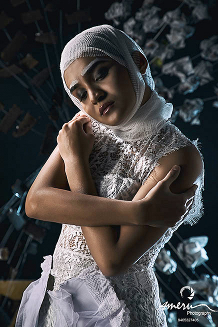 Dramatic studio portrait featuring bold contemporary styling, textured fabric details, and directional lighting