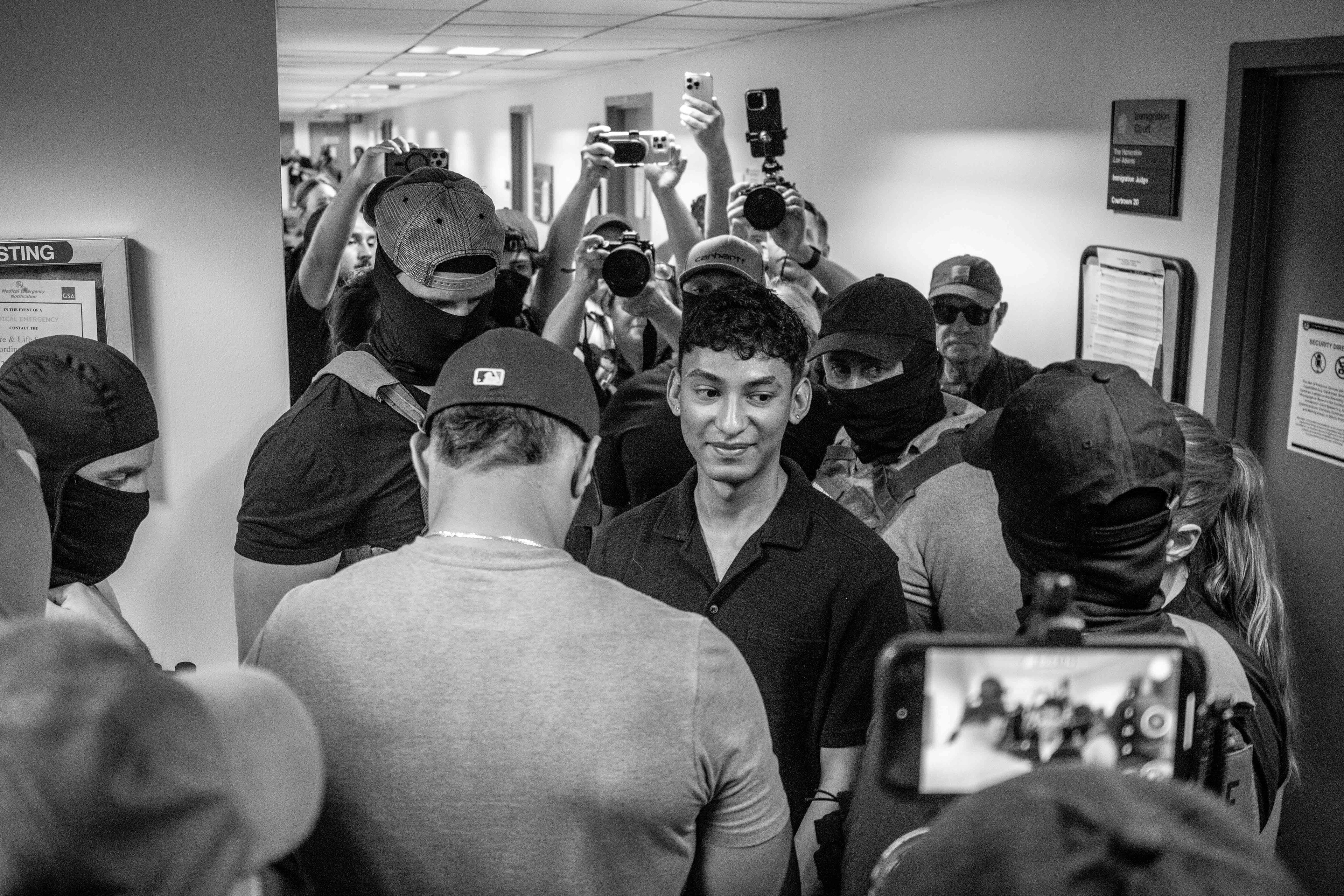 A young man is surrounded and questioned by federal agents after his court appointment in 26 Federal Plaza. The agents would let him go.