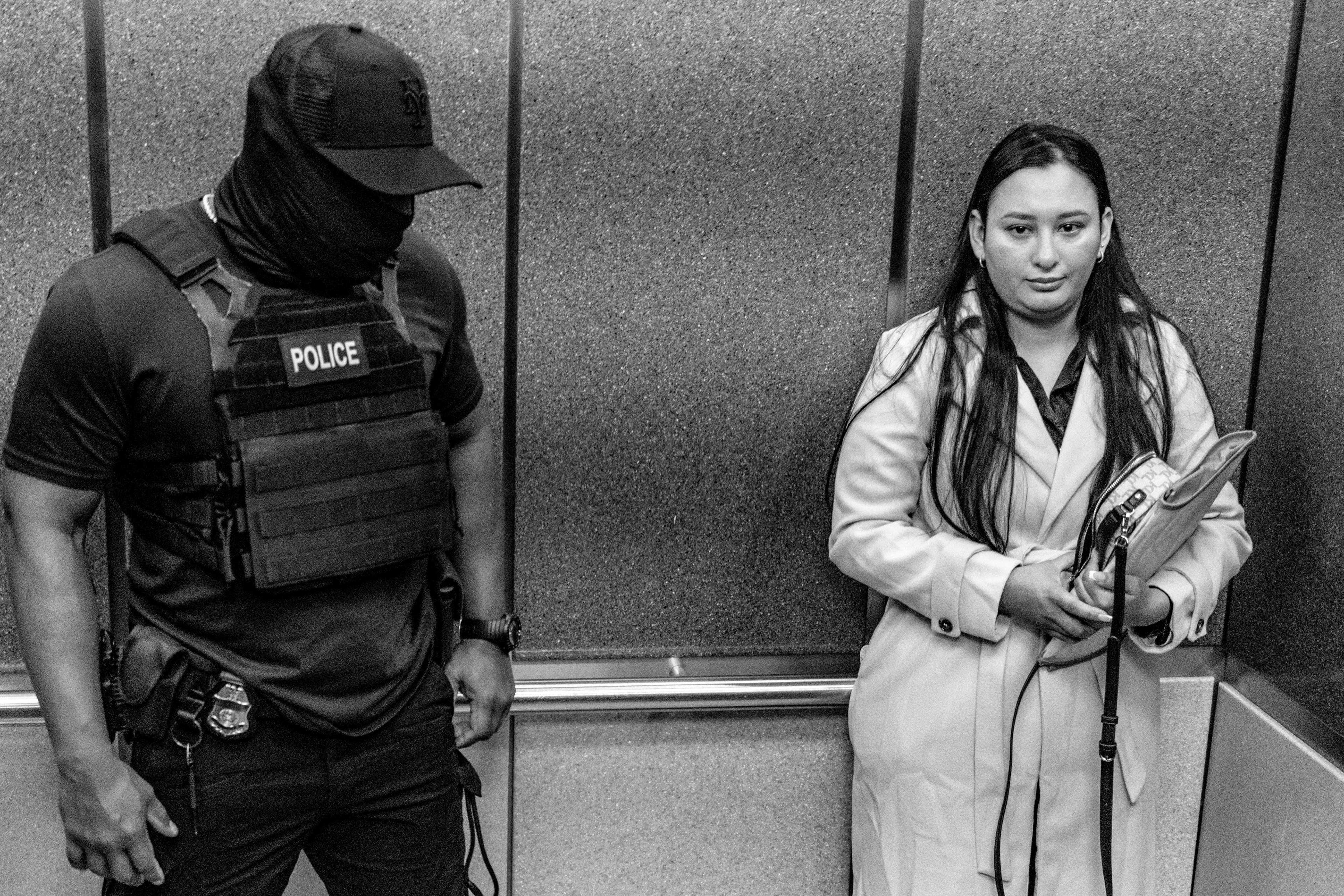 A federal agent enters an elevator with a respondent.  Agents often employ this tactic to question migrants about their identity/status out of view of the press.