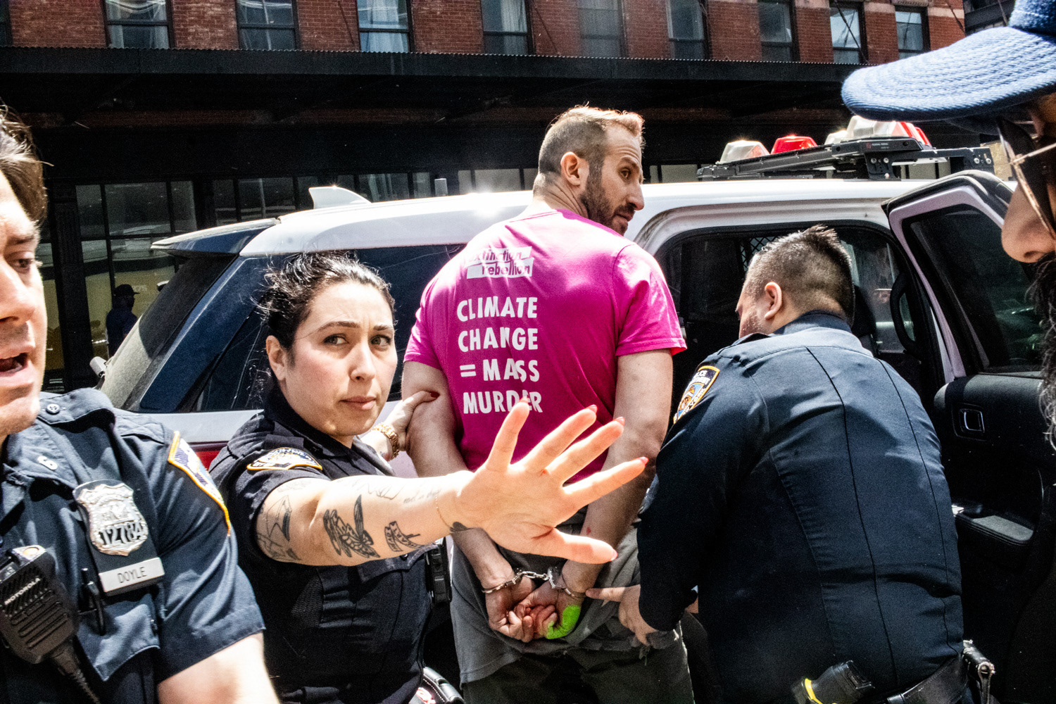 A Climate Change activist is arrested after spray painting a Tesla Dealership in New York, New York on April 22nd, 2025.