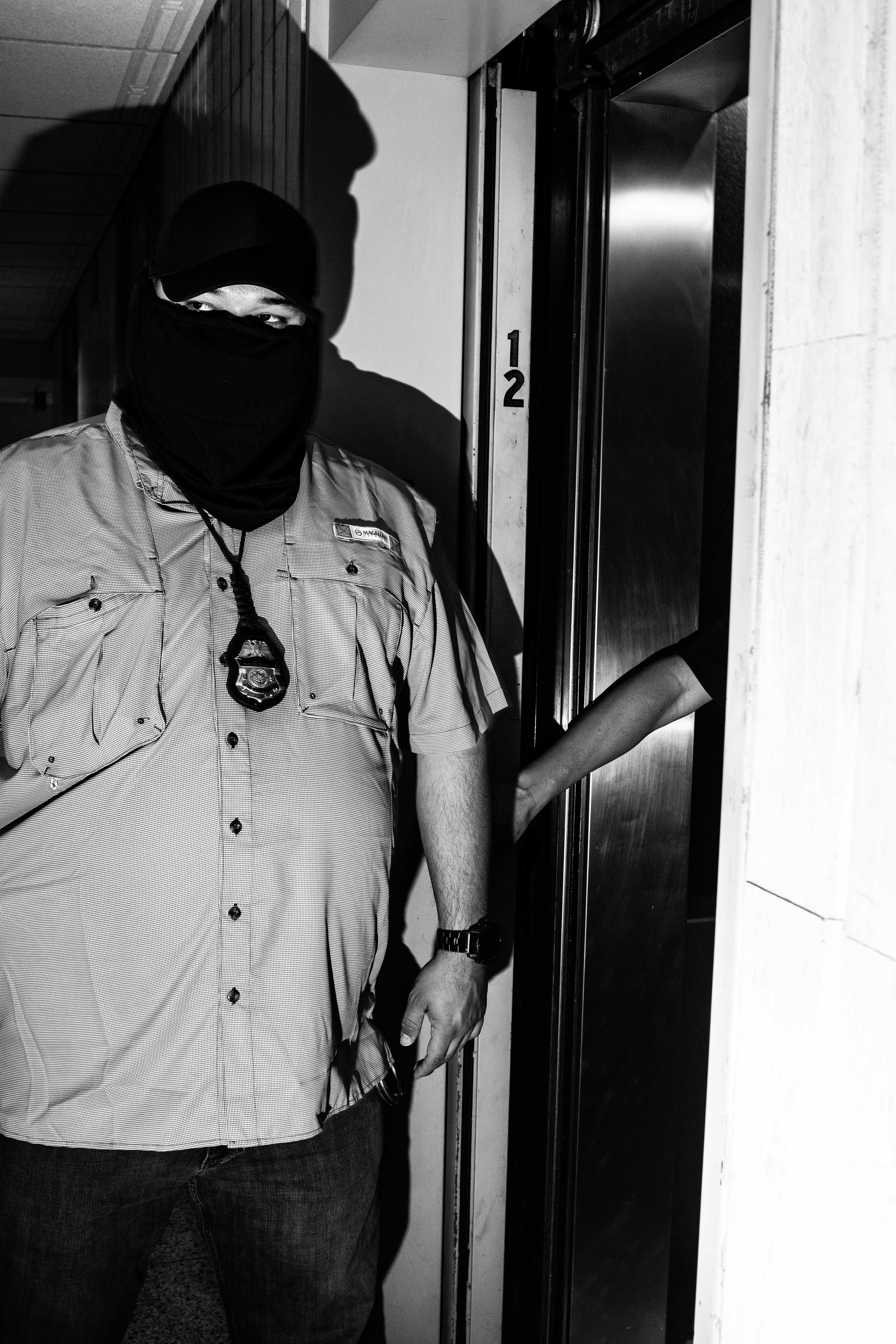 A federal agent enters the hallway at 26 Federal Plaza.