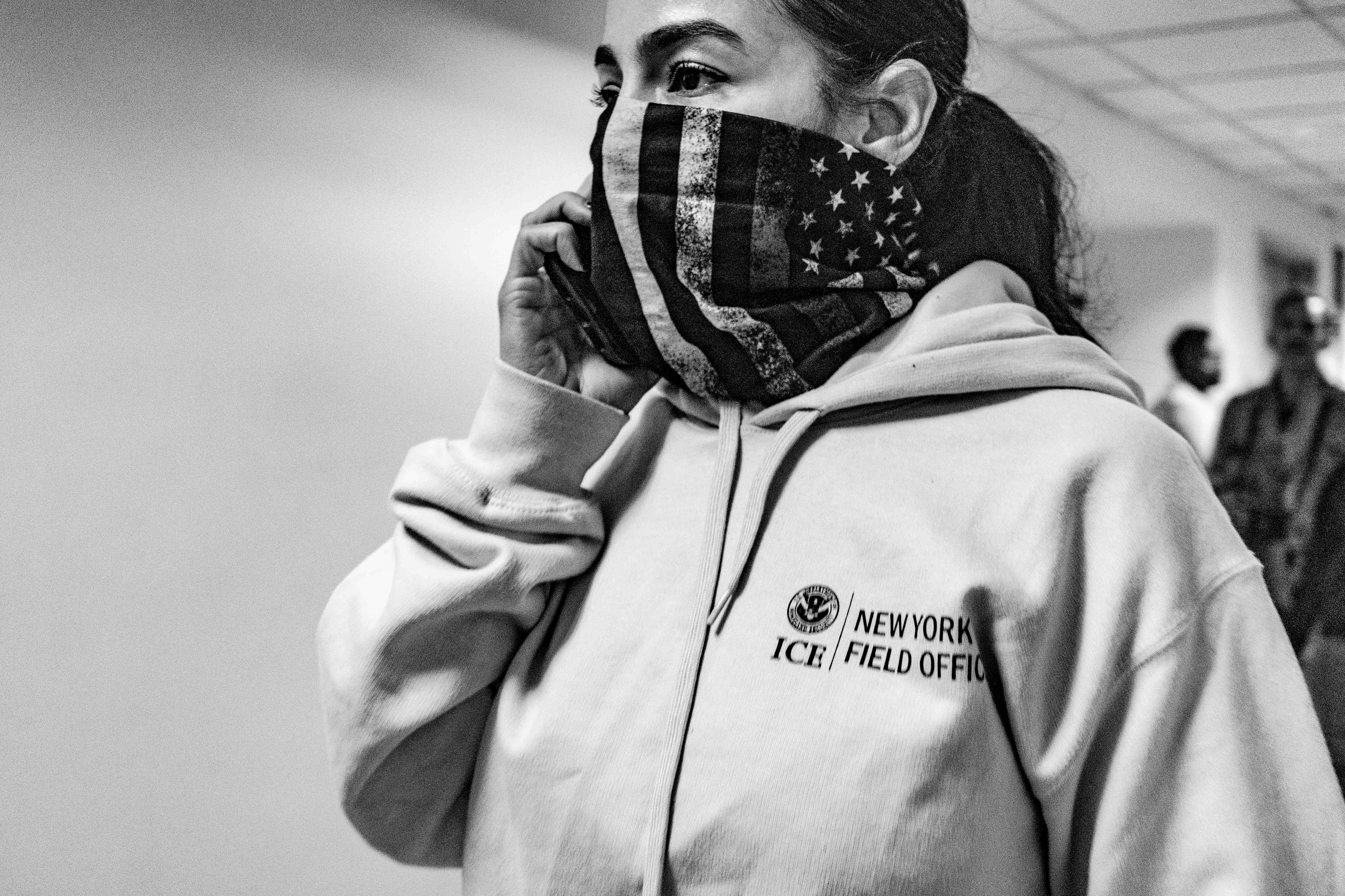 An ICE agent walks the halls of 26 Federal Plaza while on a phone call.