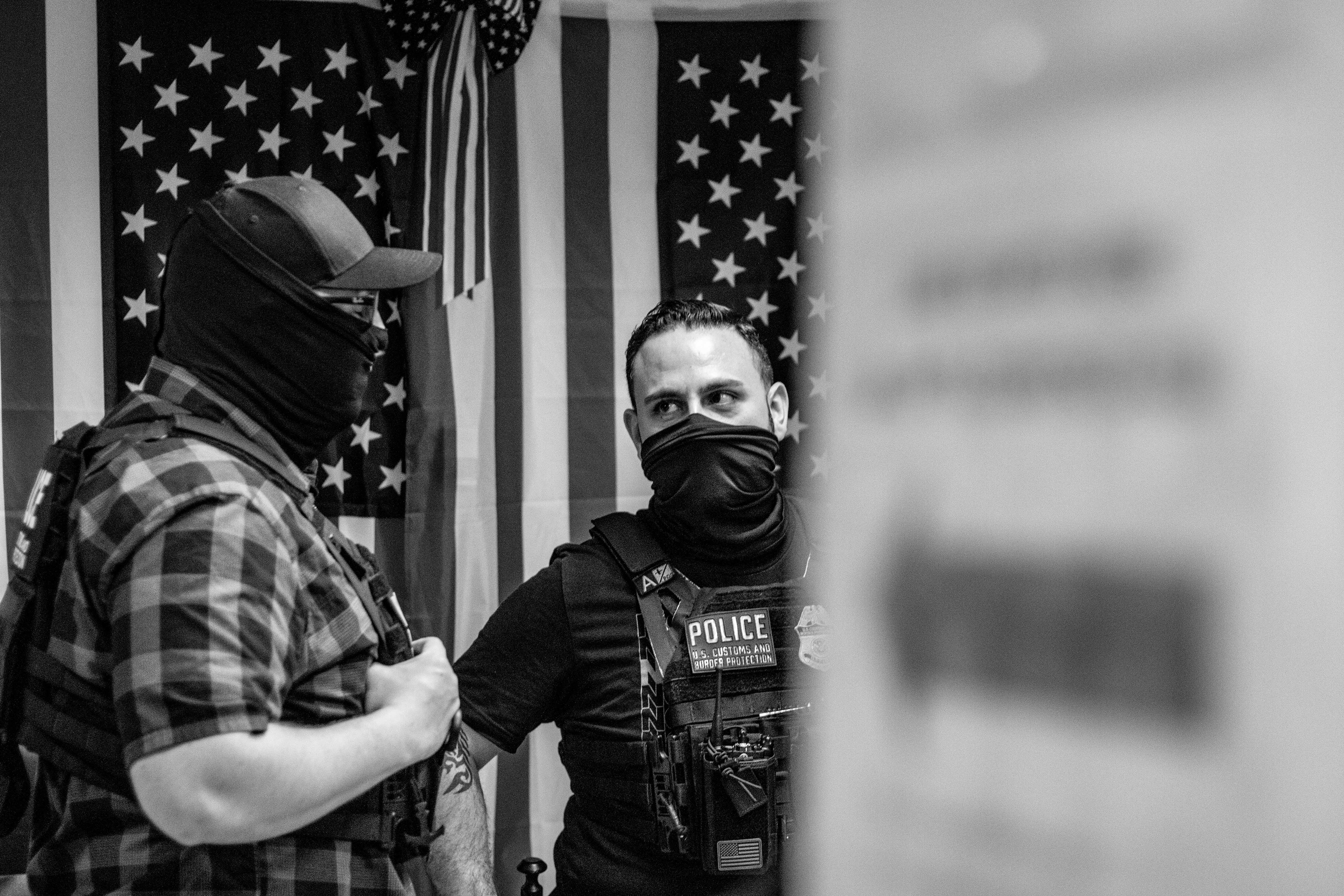 Two federal agents mingle in the hallways.