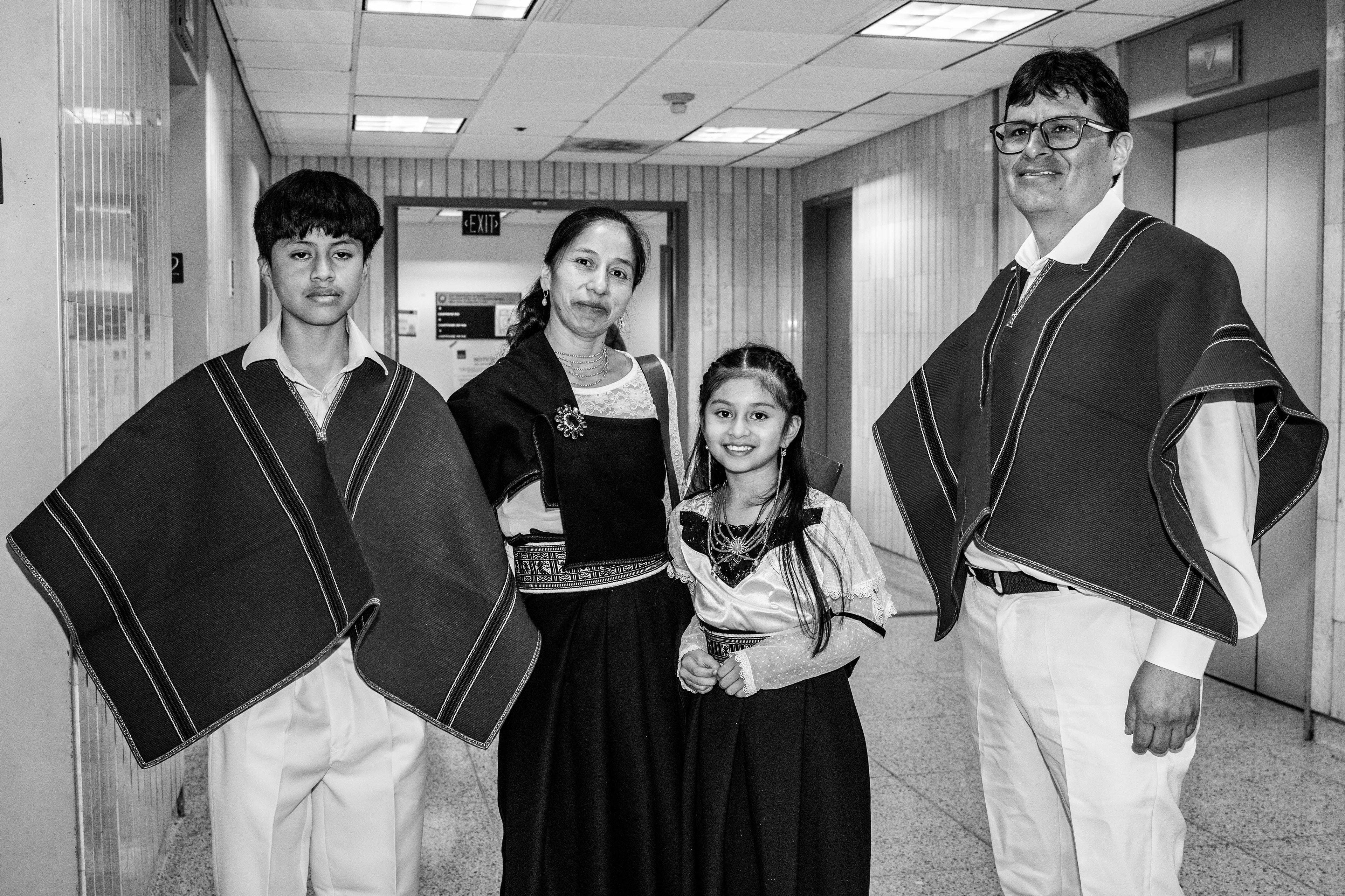 A family stops for a photo while waiting for the elevator. They had their court hearing and we're now leaving; many respondents do not.