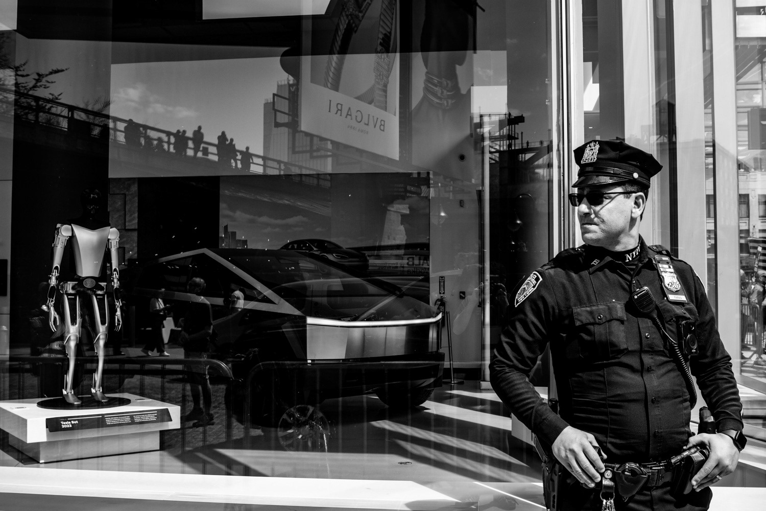 A member of NYPD stands outside of a Tesla dealership in New York, New York on March 29th, 2025. Nationwide protests at Tesla's dealership have become commonplace with Tesla owner Elon Musk's involvement in the Trump administration.
