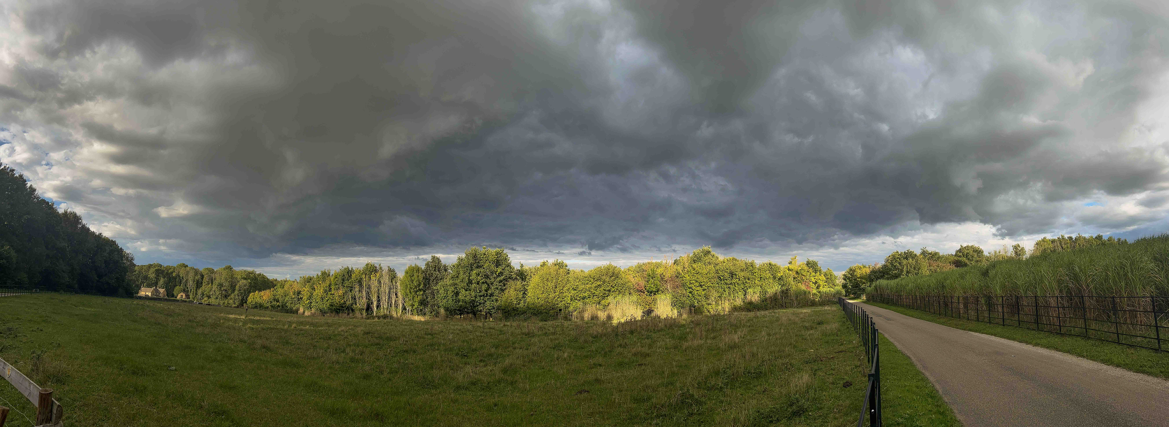 Storm cloud overhead with sunshine ahead. iPhone Panoramic image