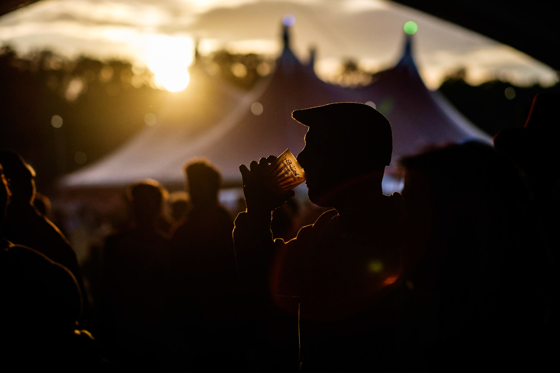 Atmosphere at WOMAD (World of Music, Arts and Dance)  Festival at Charlton Park on 25/07/2015 at Charlton Park, Malmesbury.  Festival goers relax and enjoy a beer  in the Bowers &amp; Wilkins stage tent bathed in the light of the sunset. Picture by Julie Edwards/Photoshot