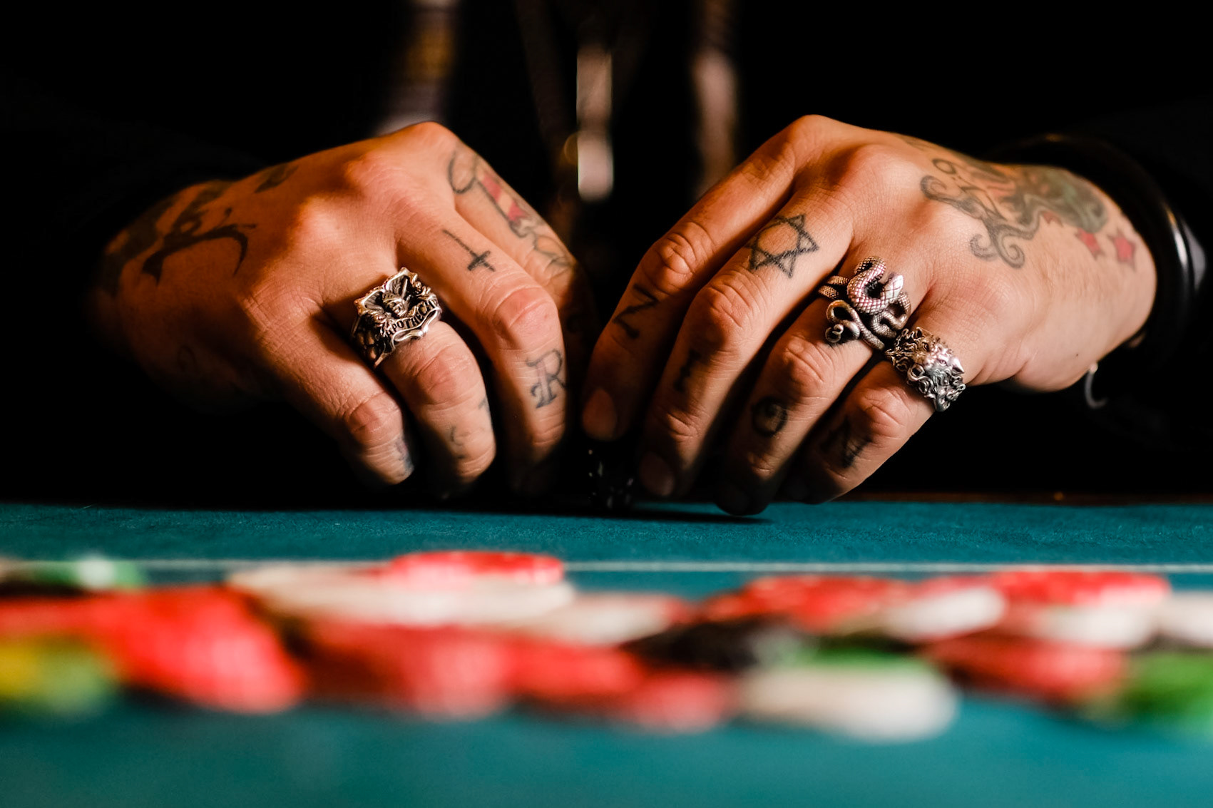 Tattooed hands spin a gambling chip at Vincent Kamp - The Long Game - Private View on Thursday 8 November 2018 held at Clarendon Fine Art, Dover Street, London. The private view at the gallery brought the Kamp's new works to life by bringing the characters in the paintings into the gallery.