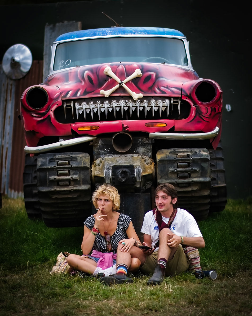 A couple sit in front of a car at Joe Rush's Carhenge seen  on the first day during the Glastonbury Festival 2025 at Worthy Farm, Pilton, , UK on 25 June 2025. Picture Credit: Julie Edwards/Avalon.