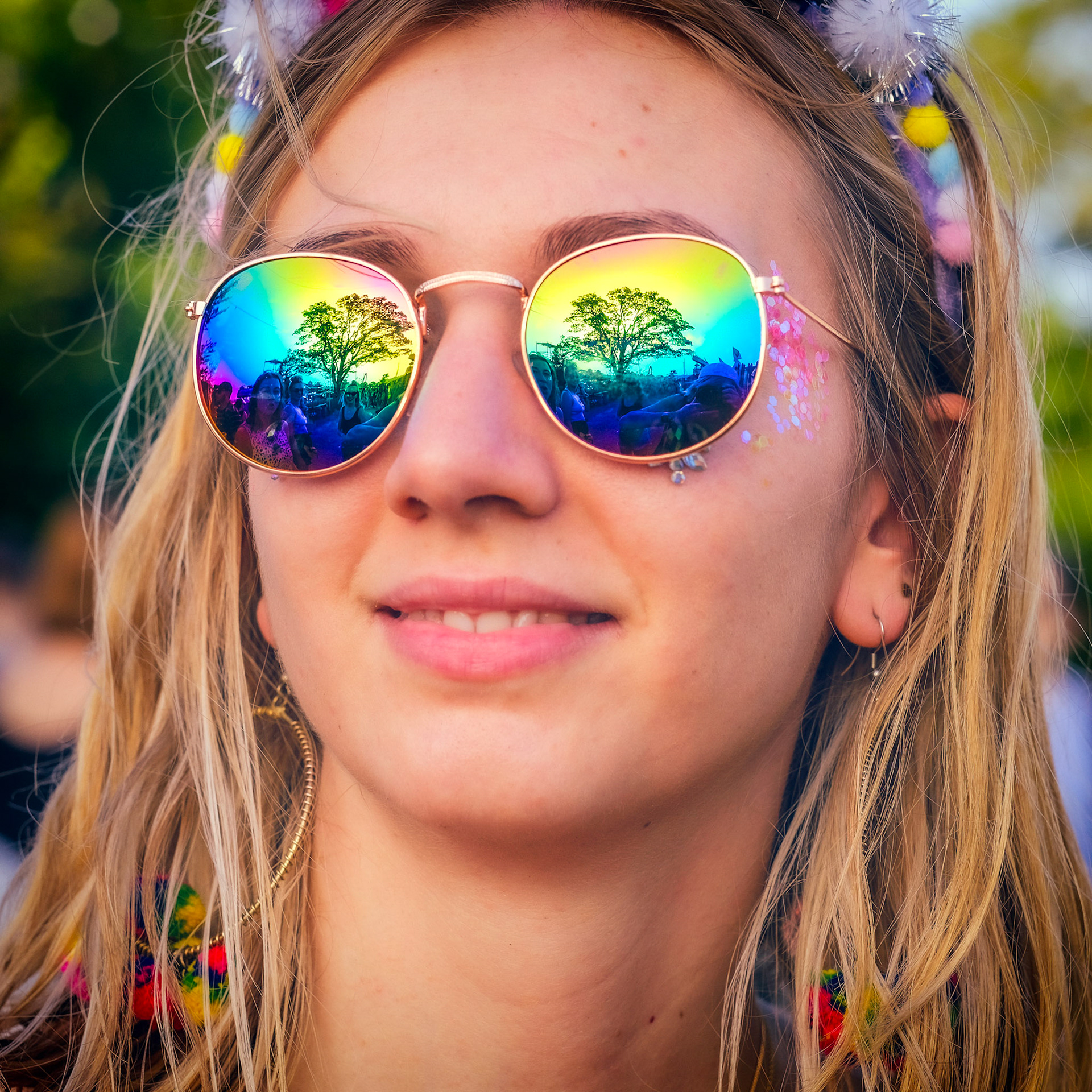 Atmosphere  at Glastonbury Festival 2019 on Thursday 27 June 2019 at Worthy Farm, Pilton. A tree backlight by the sun is reflected in the mirrored sunglasses of young women. Picture by Julie Edwards/LFI/Avalon. All usages must be credited Julie Edwards/LFI/Avalon.