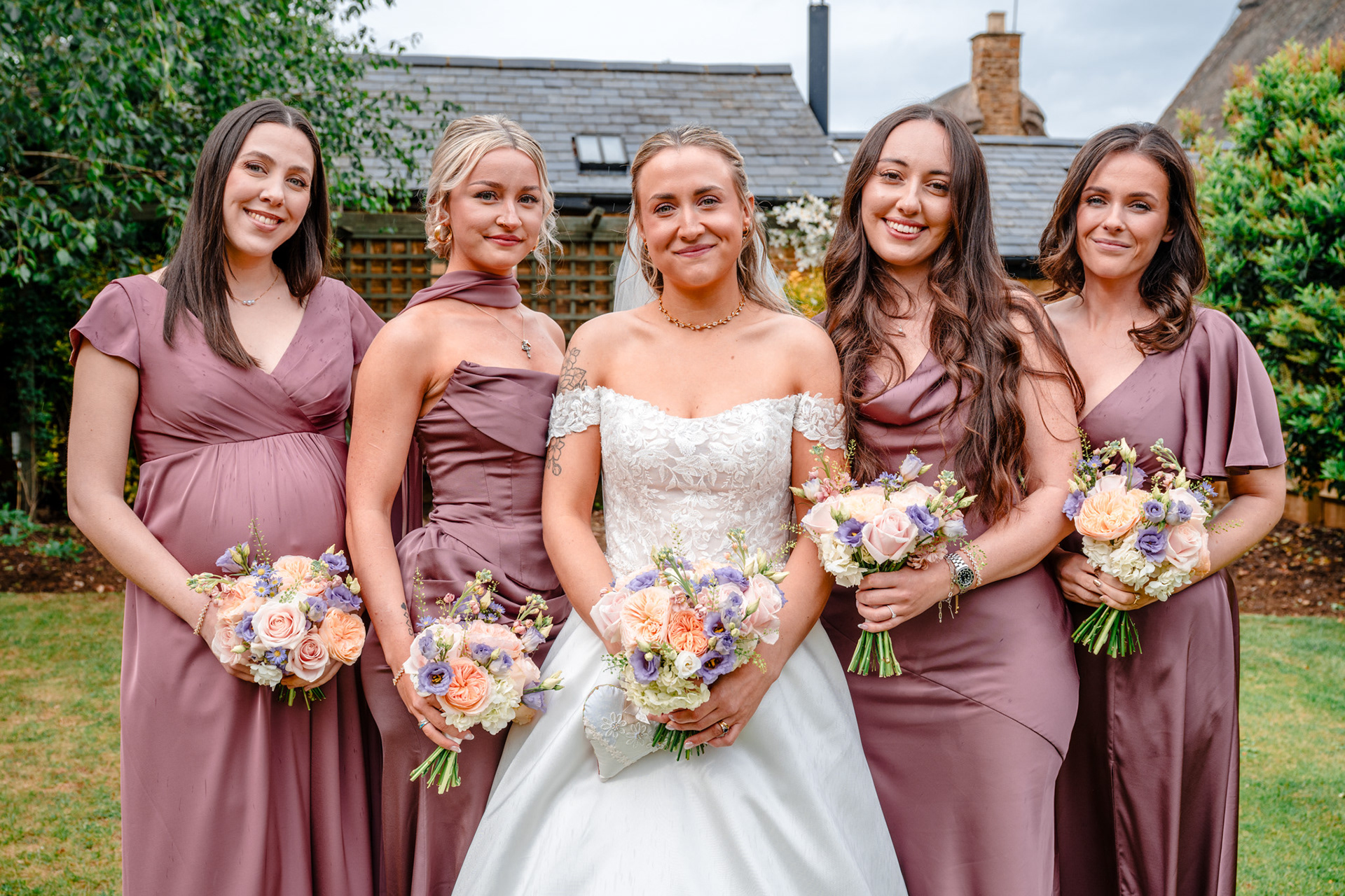 A bride poses for a close up with her bridesmaids.