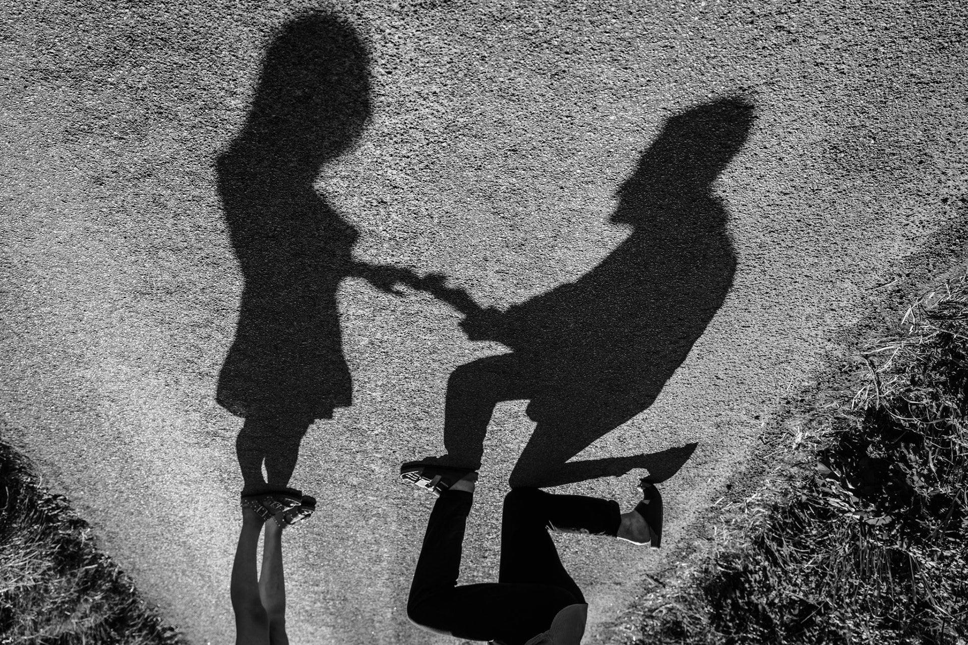 A black and white photograph of a couple's shadow as they propose.