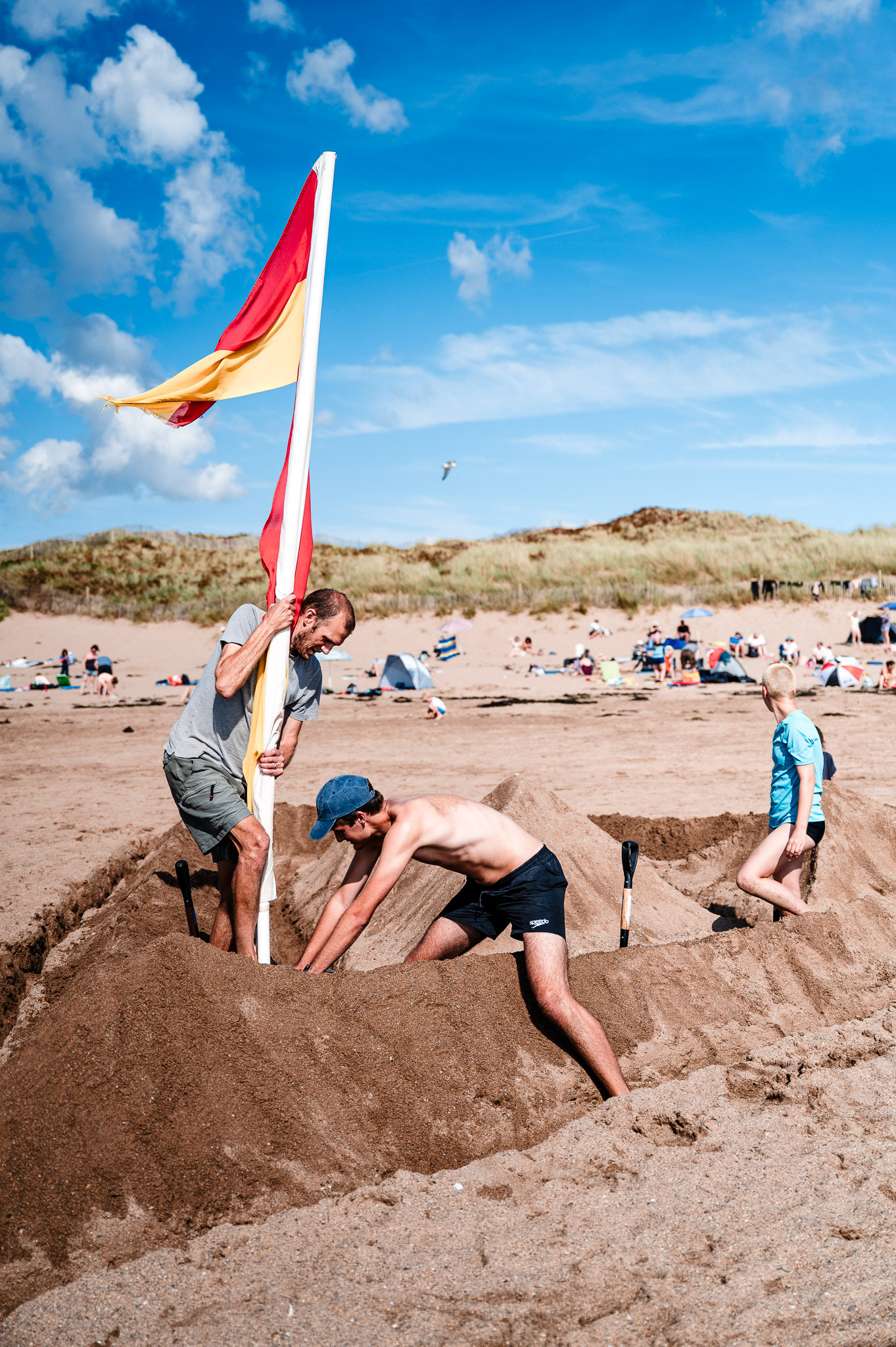 A flag is raised during the building of a sandcastle at a Devon beach.