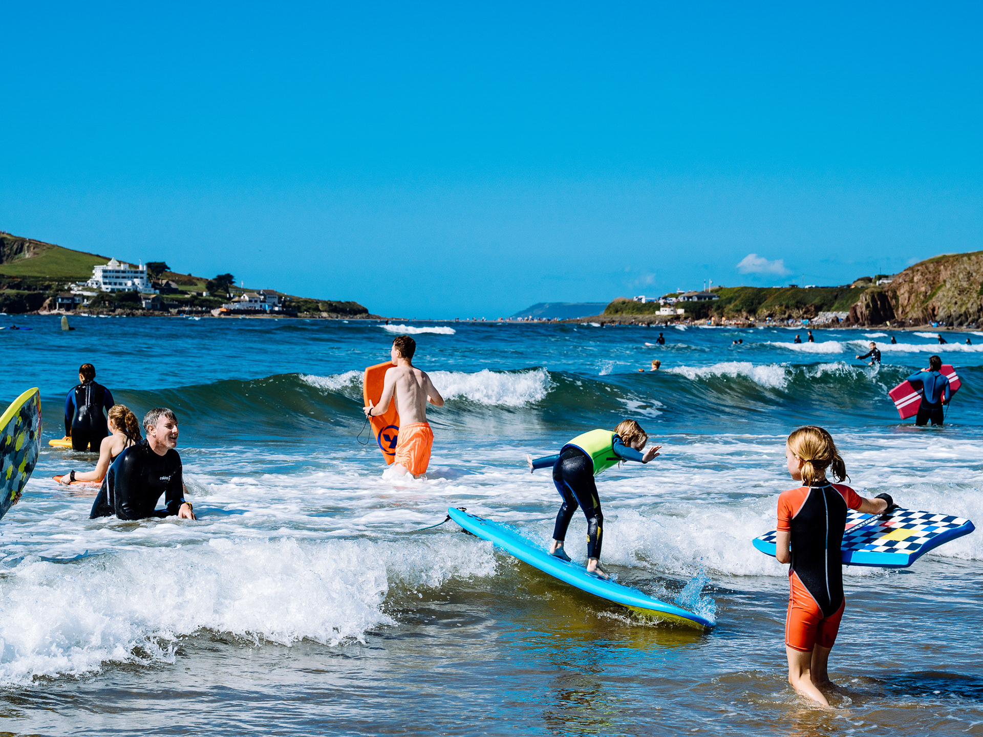 Holiday makers play in the waves at Devon's Bantham beach.