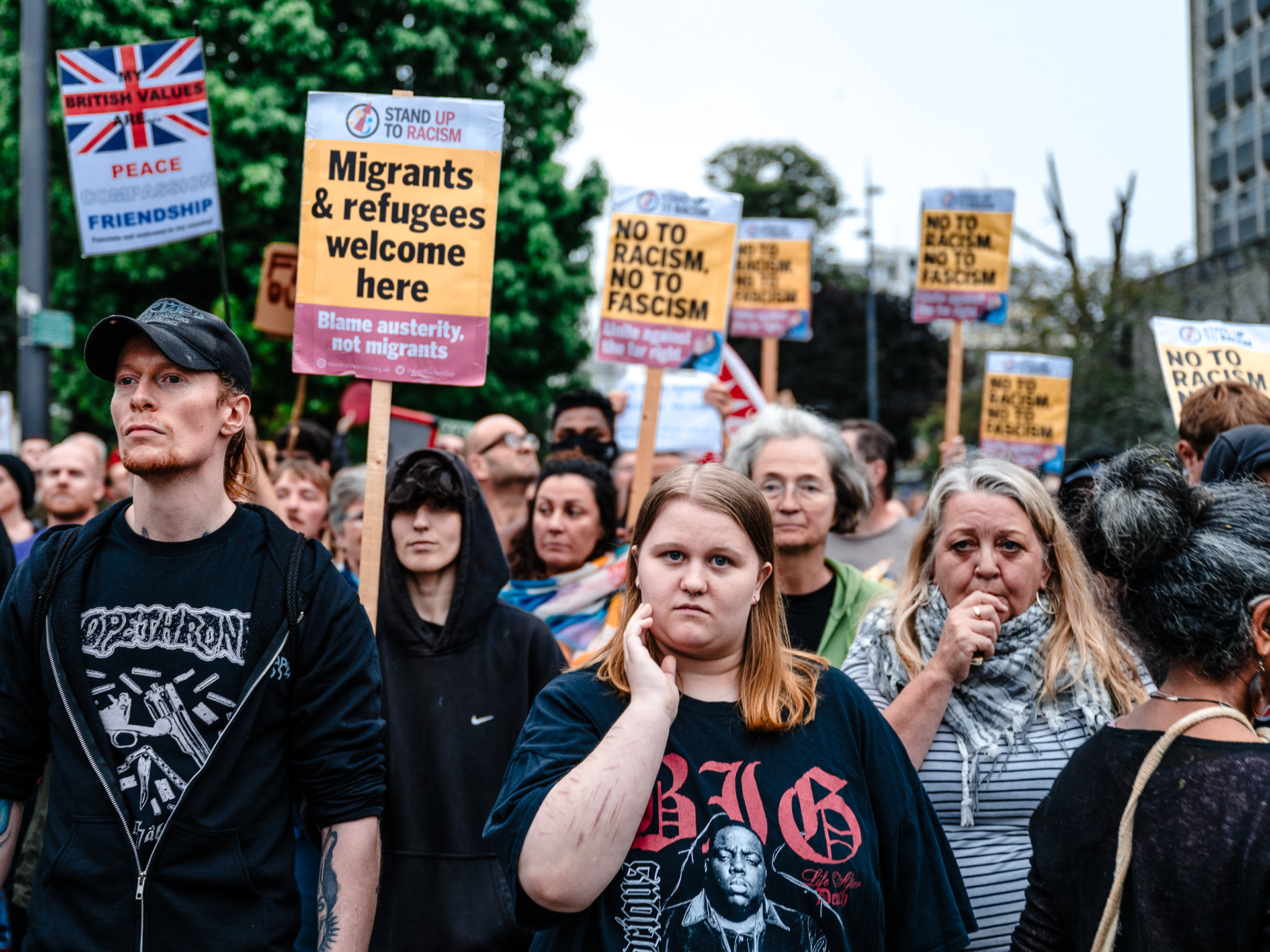 A group of Stand Up to Racism protesters look anxiously towards the camera.
