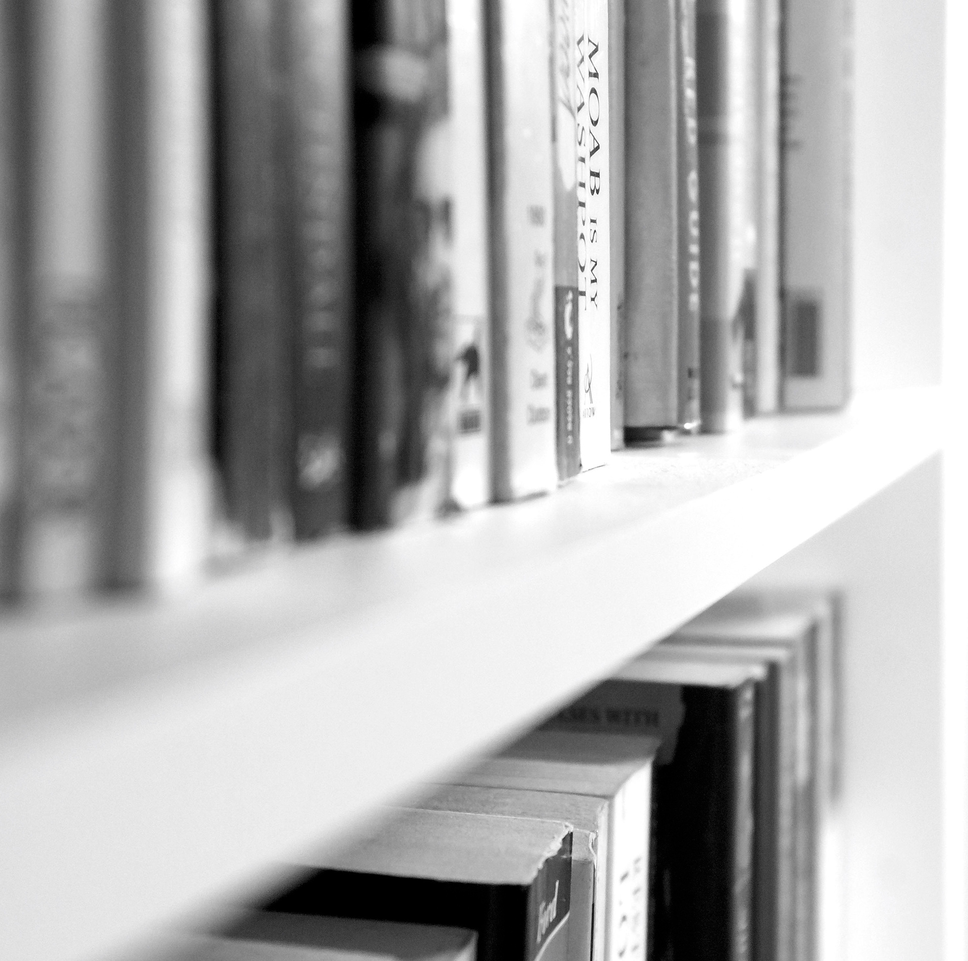 Black and white image of books on white shelves