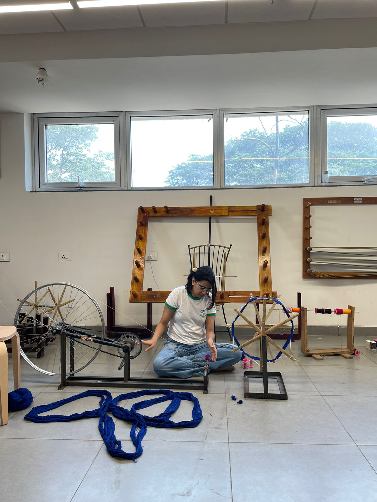 Winding the yarn onto the bobbin, making it ready for use in weaving, at Weaving Studio in IDC, IIT Bombay.