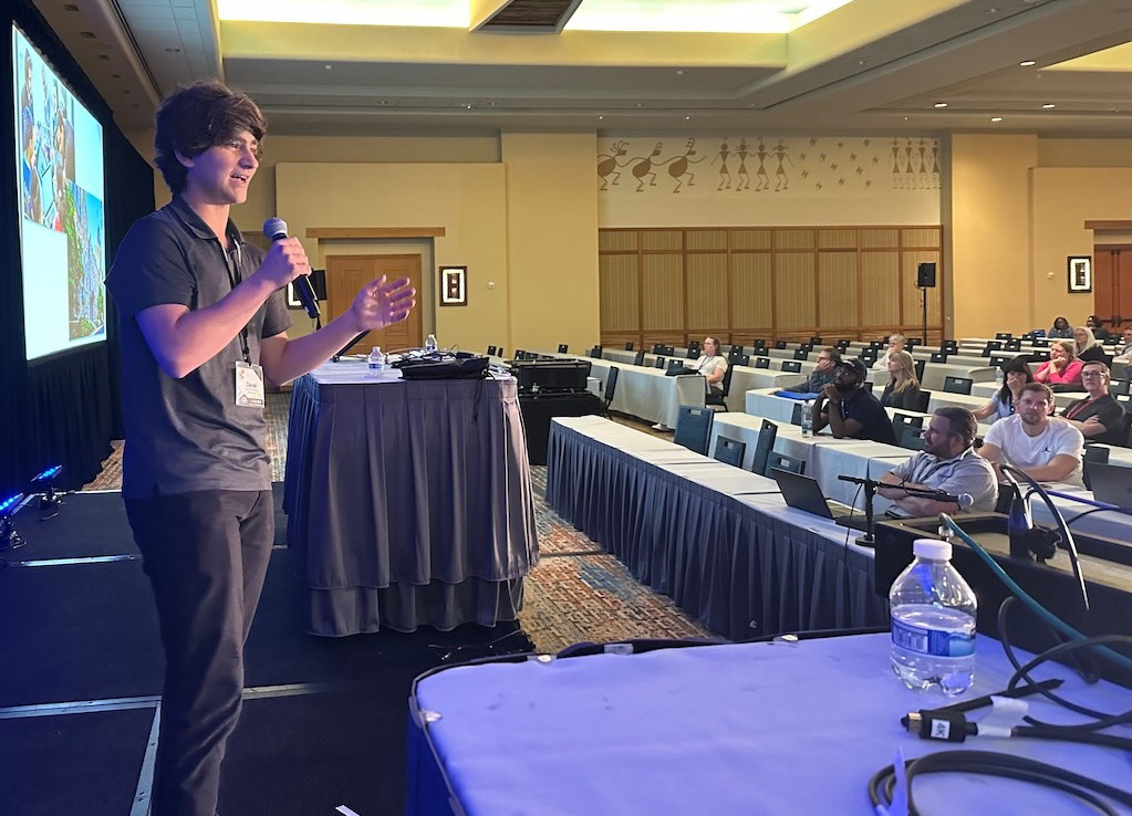 Daniel presenting on stage in front of conference attendees