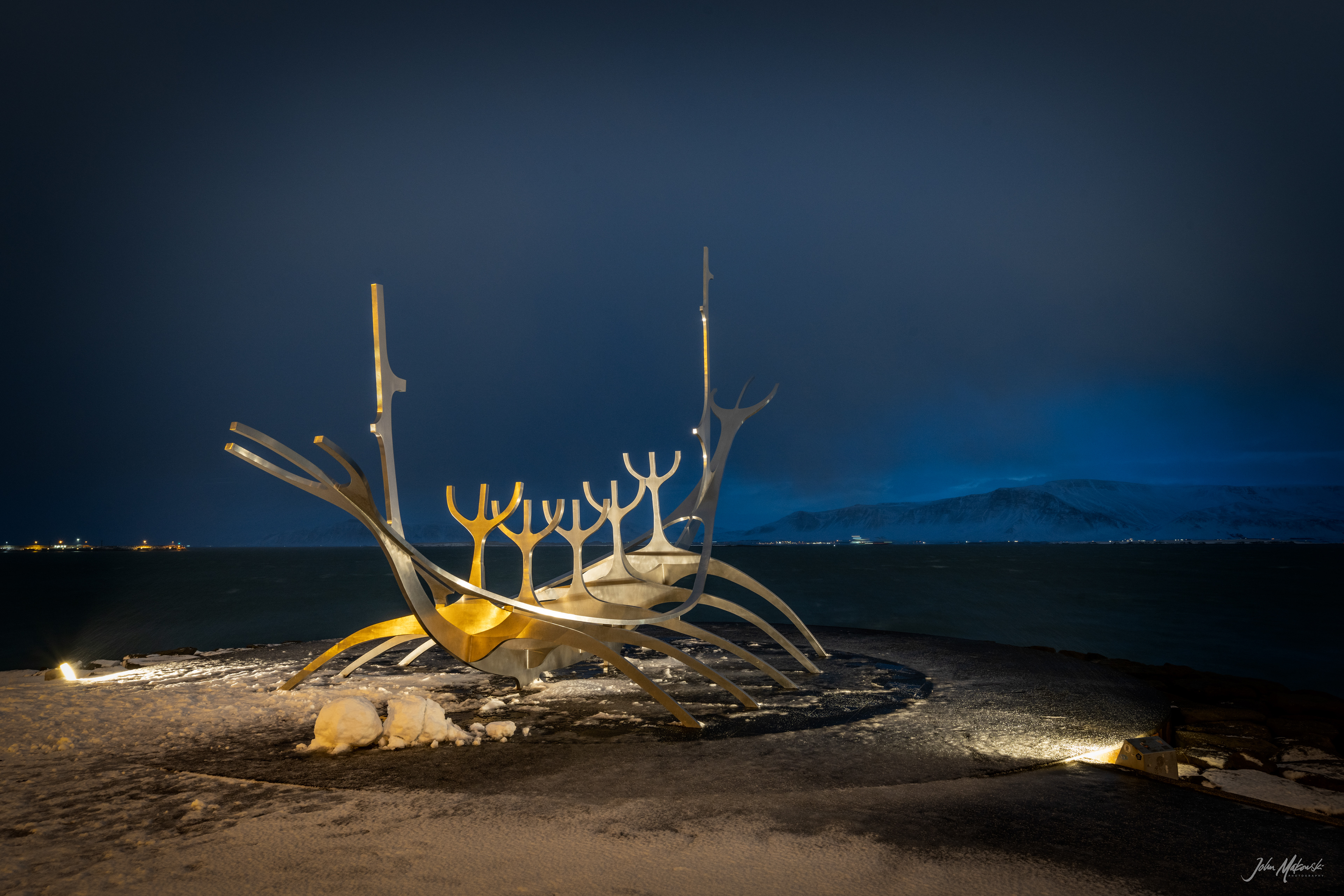 Solfarid (Sun Voyager) sculpture before sunrise on the bay at Reykjavik with Mount Esja in the background.  The sculpture represents a dream boat and an ode to the sun. It represents the promise of undiscovered territory and a dream of hope, progress and freedom.