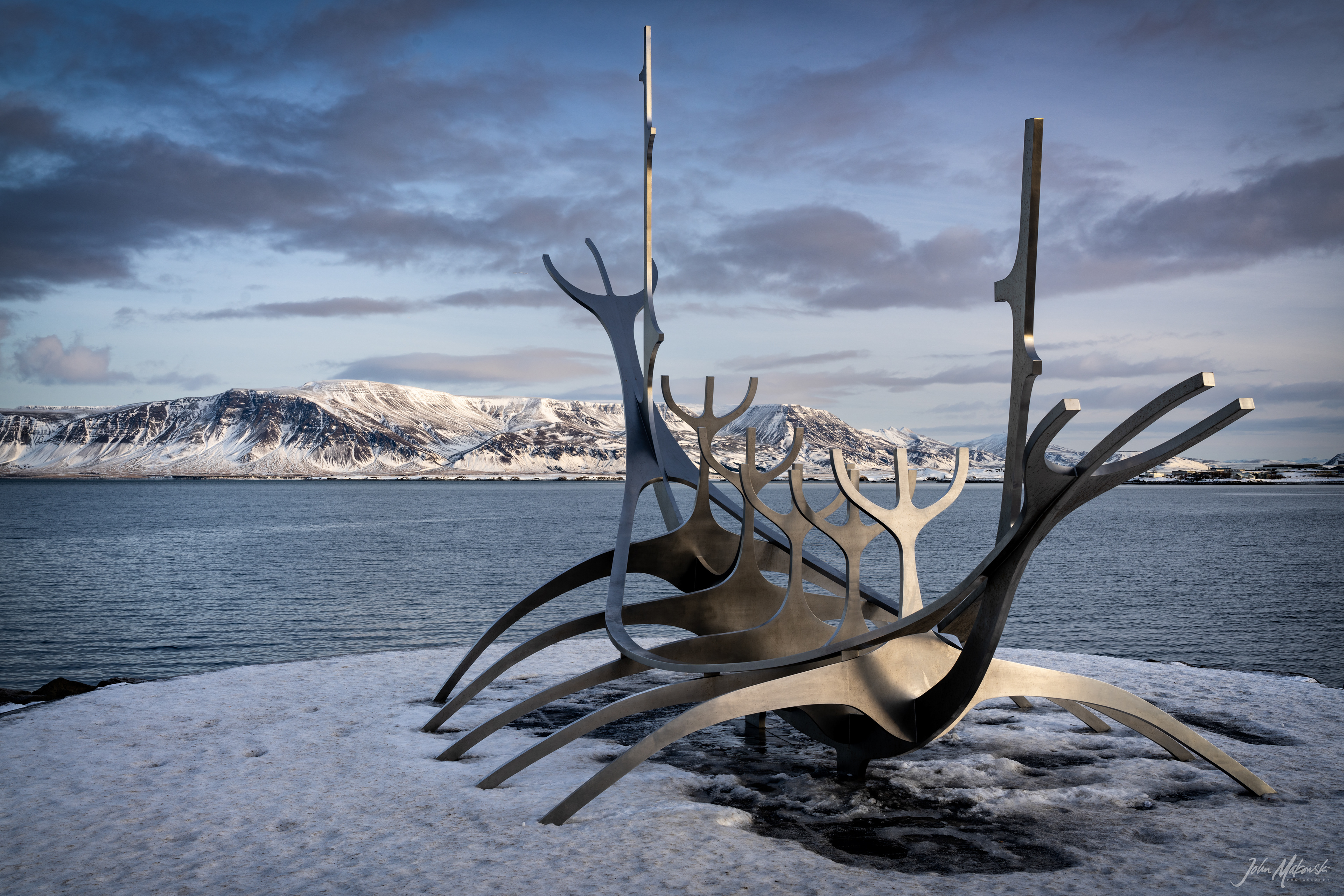 Solfarid (Sun Voyager) sculpture on the bay at Reykjavik with Mount Esja in the background.  The sculpture represents a dream boat and an ode to the sun. It represents the promise of undiscovered territory and a dream of hope, progress and freedom.