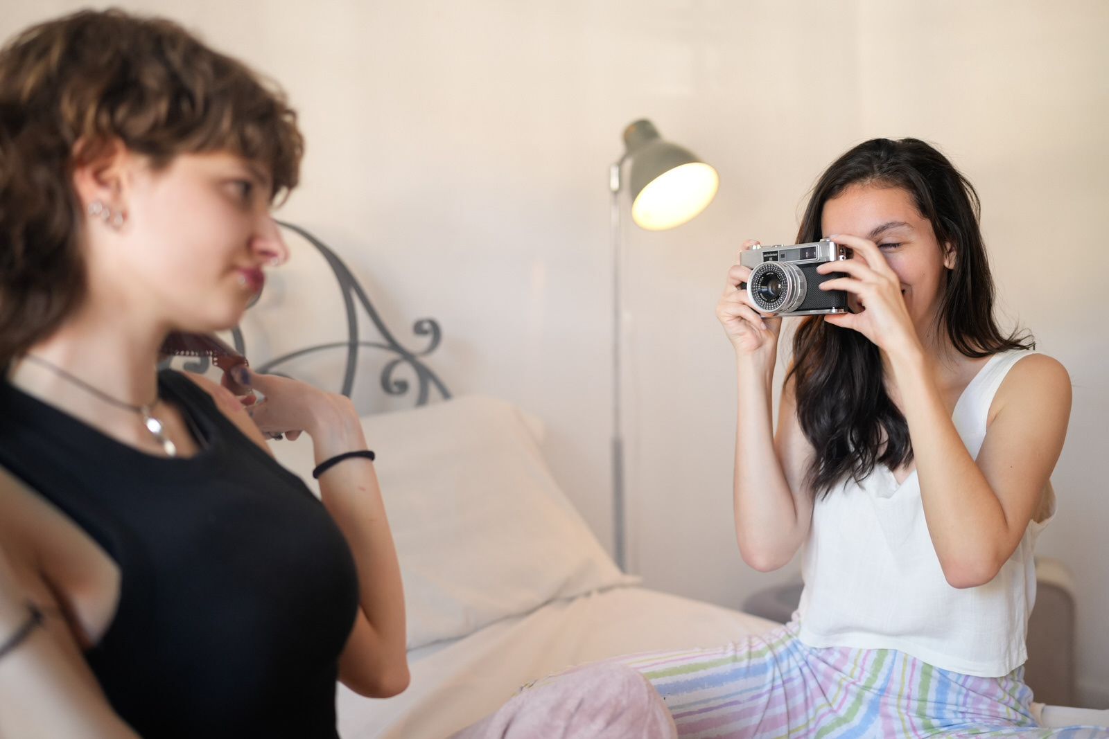 Young woman taking a photo with a vintage camera during a relaxed indoor moment