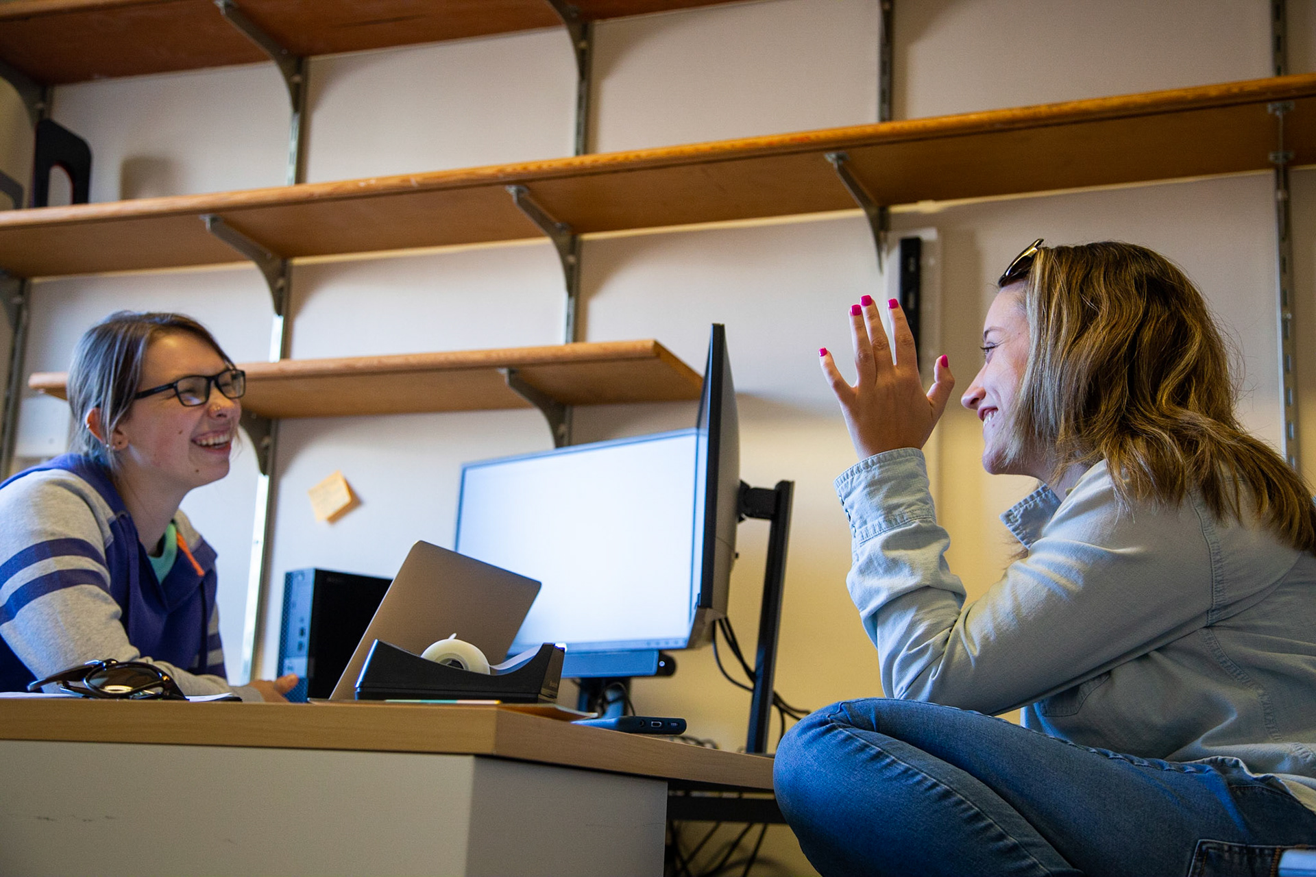Meghan laughs with her roomate Rexy at the InclusiveU office after her internship. She regularly hangs out there with her roomates and friends. Her roomate Rexy is a grad student in the Inclusive Education field and they became friends very quickly after moving in together. Rexy acts as a mentor and friend to all the students in InclusiveU.