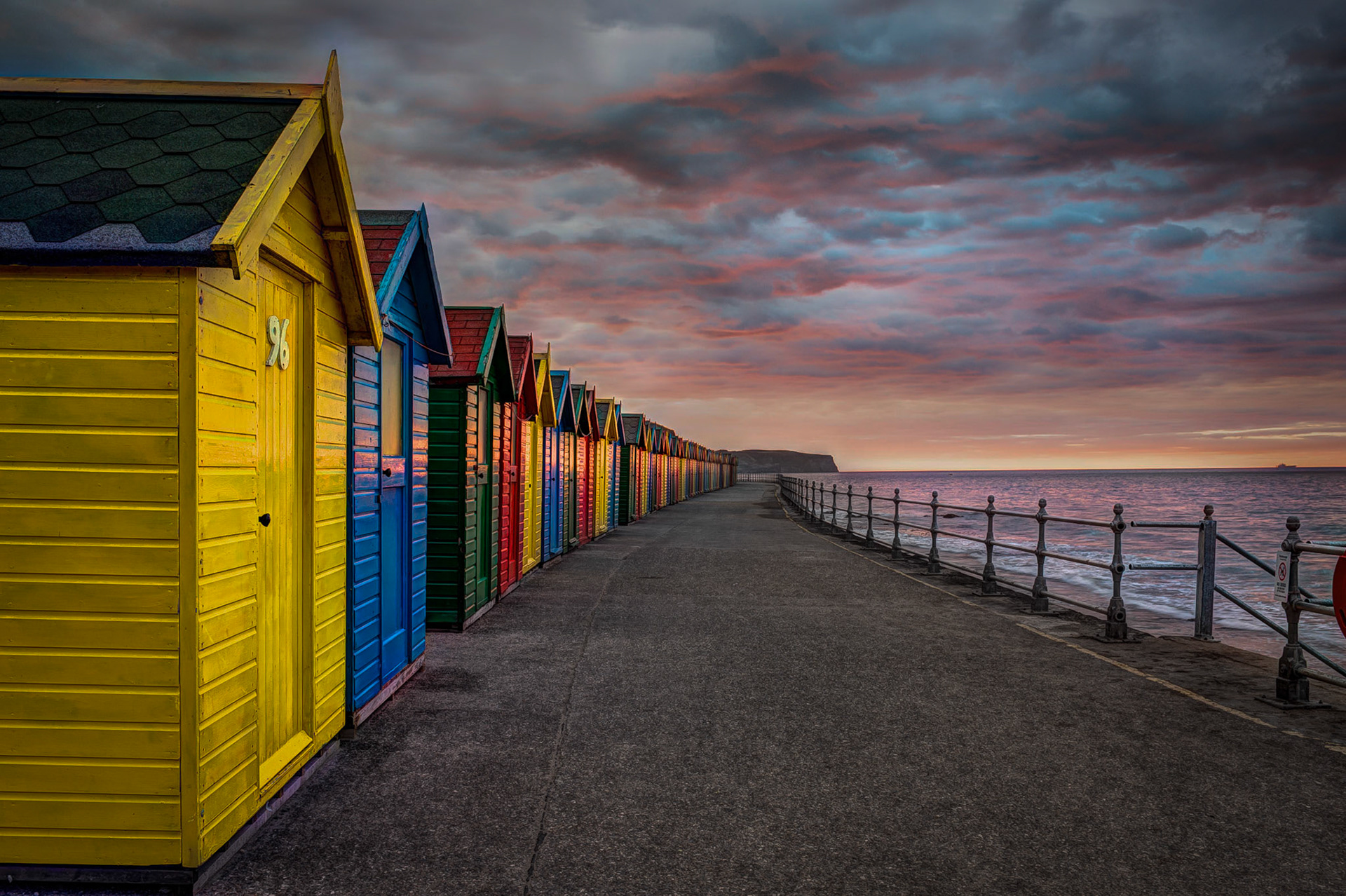 Head North from the photogenic town of Whitby to find this row of colourful beach huts complimenting a red sky form a setting sun.