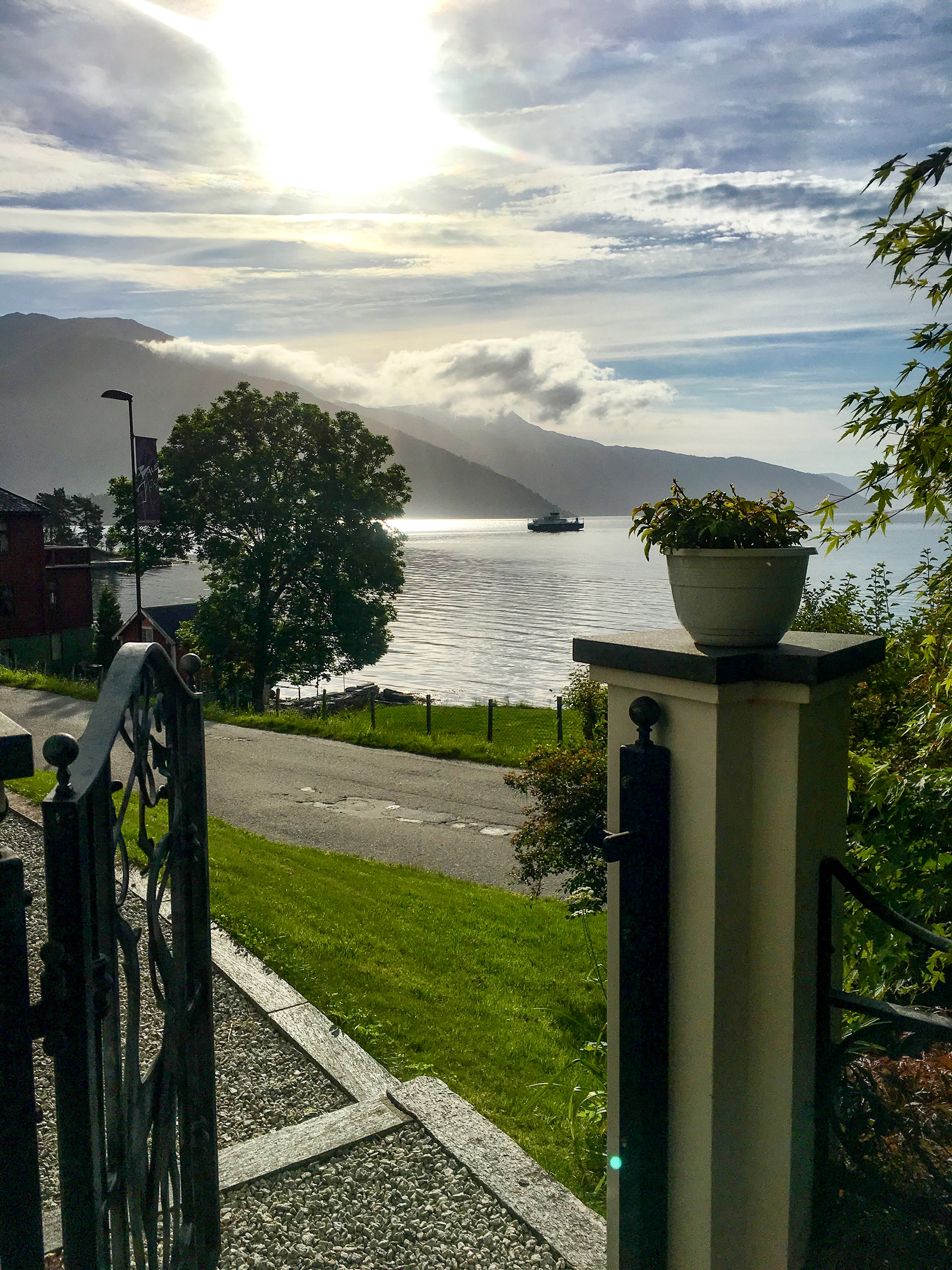 A gate opens directly onto a classic Norwegian scene, where the mountains meet the sea