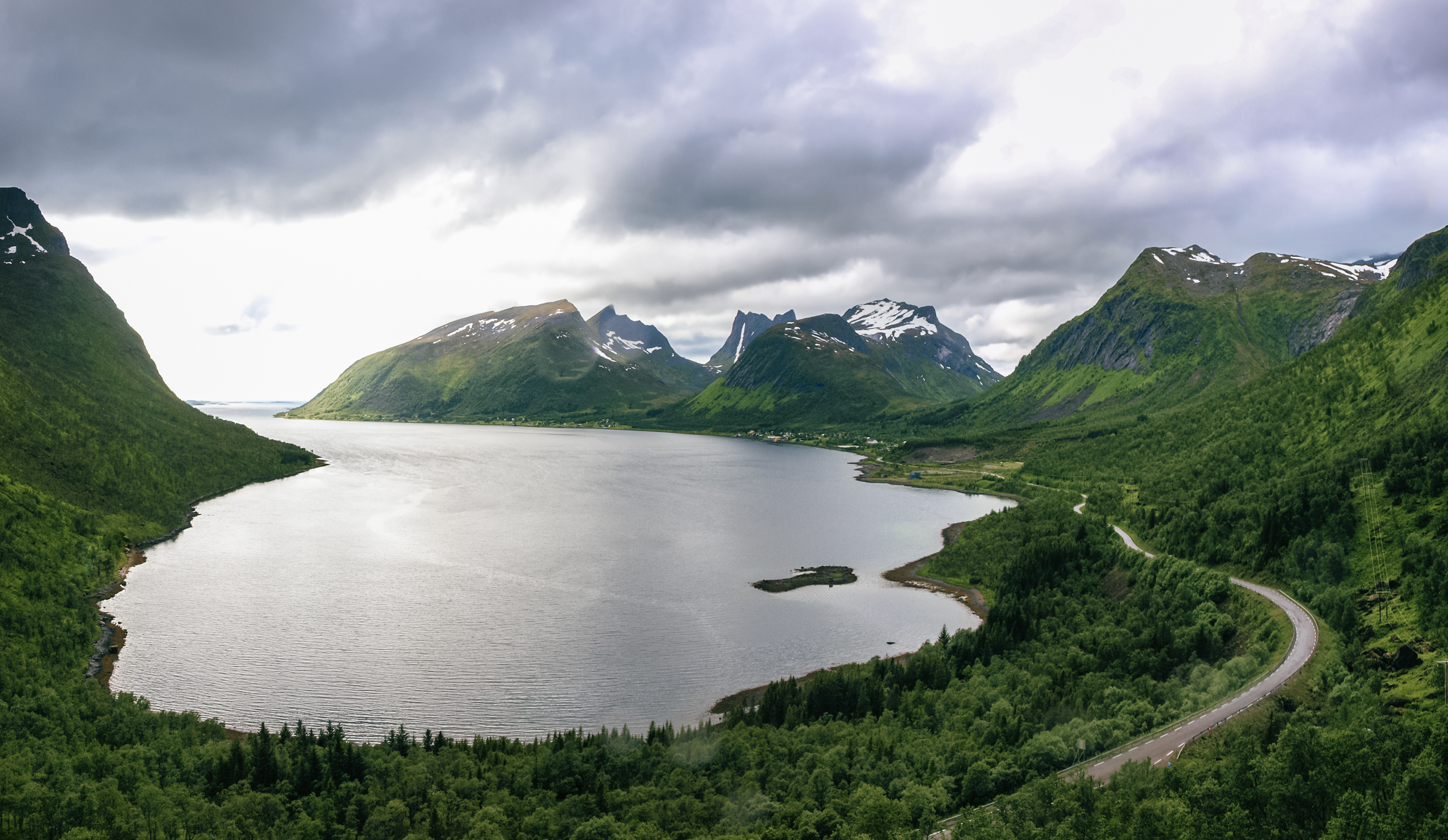 Golden light reflects off the water in Senja on the road to Skrolsvik