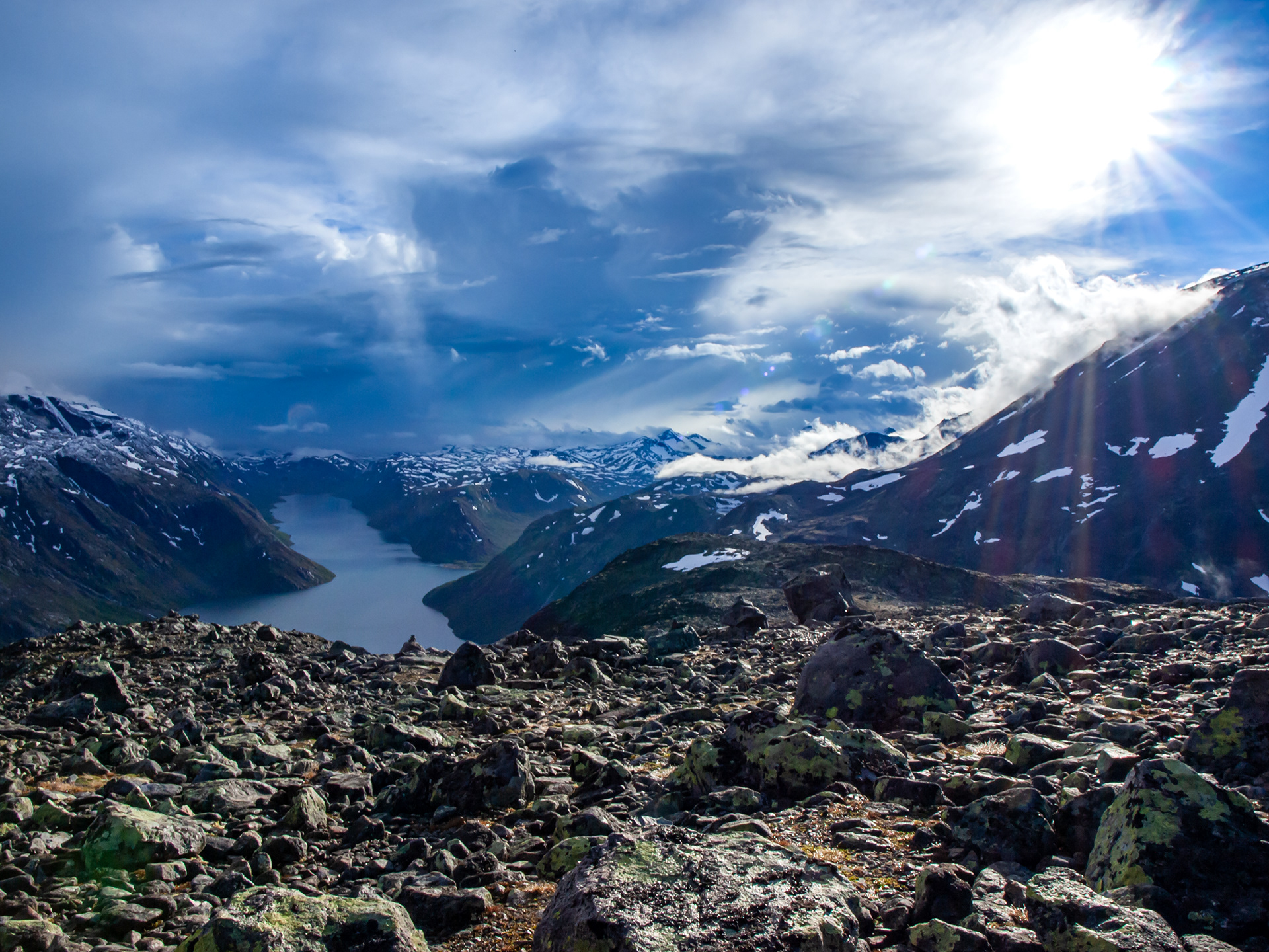 A sunburst breaks through the clouds of the impending snowstorm while hiking along the Besseggen Ridge Trail in Jotunheimen Nasjonalpark