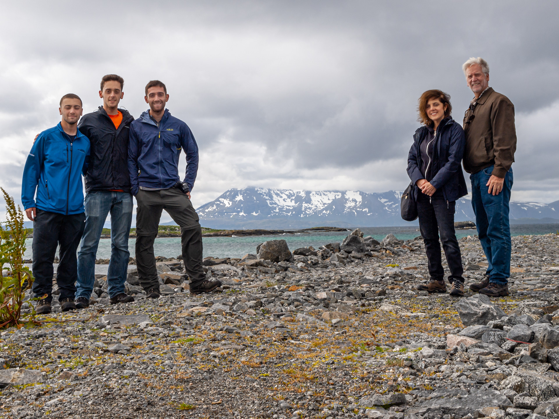 Nick, James, Rob, Paula, and Bob pose in front of some mountains in Skrolsvik