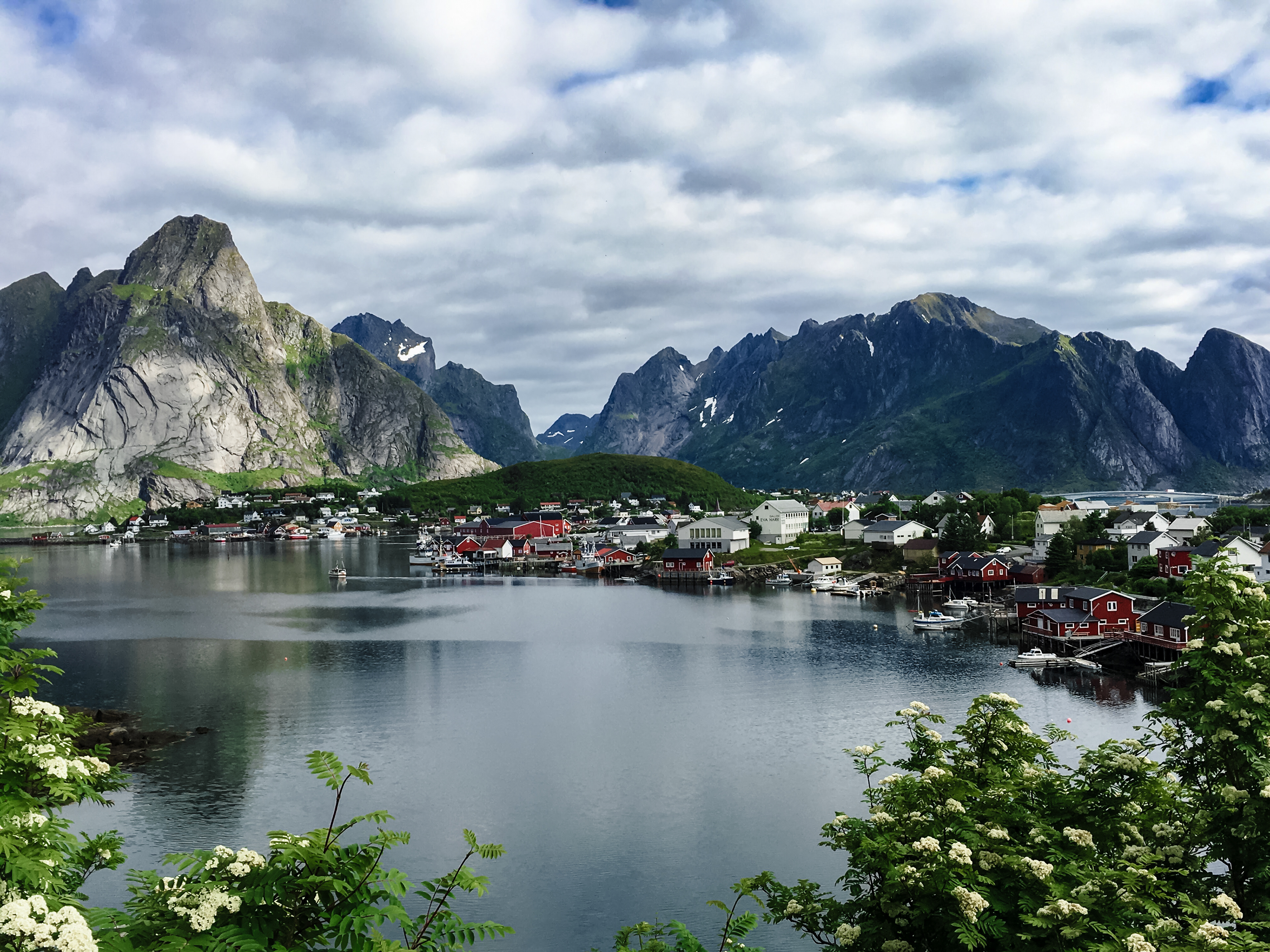 A majestic scene with the jagged peaks of Lofoten towering over the fishing village