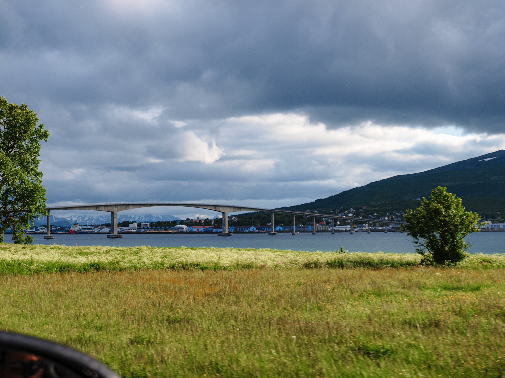 A raised bridge spans the water between two sections of the Lofoten archipelago