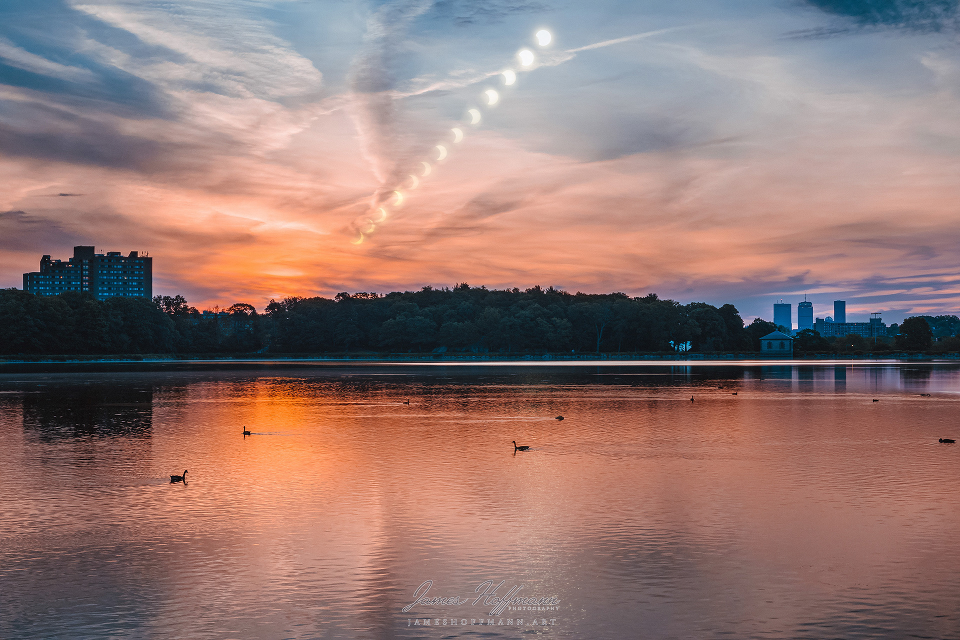 A partial annular solar eclipse at sunrise as seen from the Chestnut Hill Reservoir, with the Boston skyline in the background. Captured on June 10, 2021.