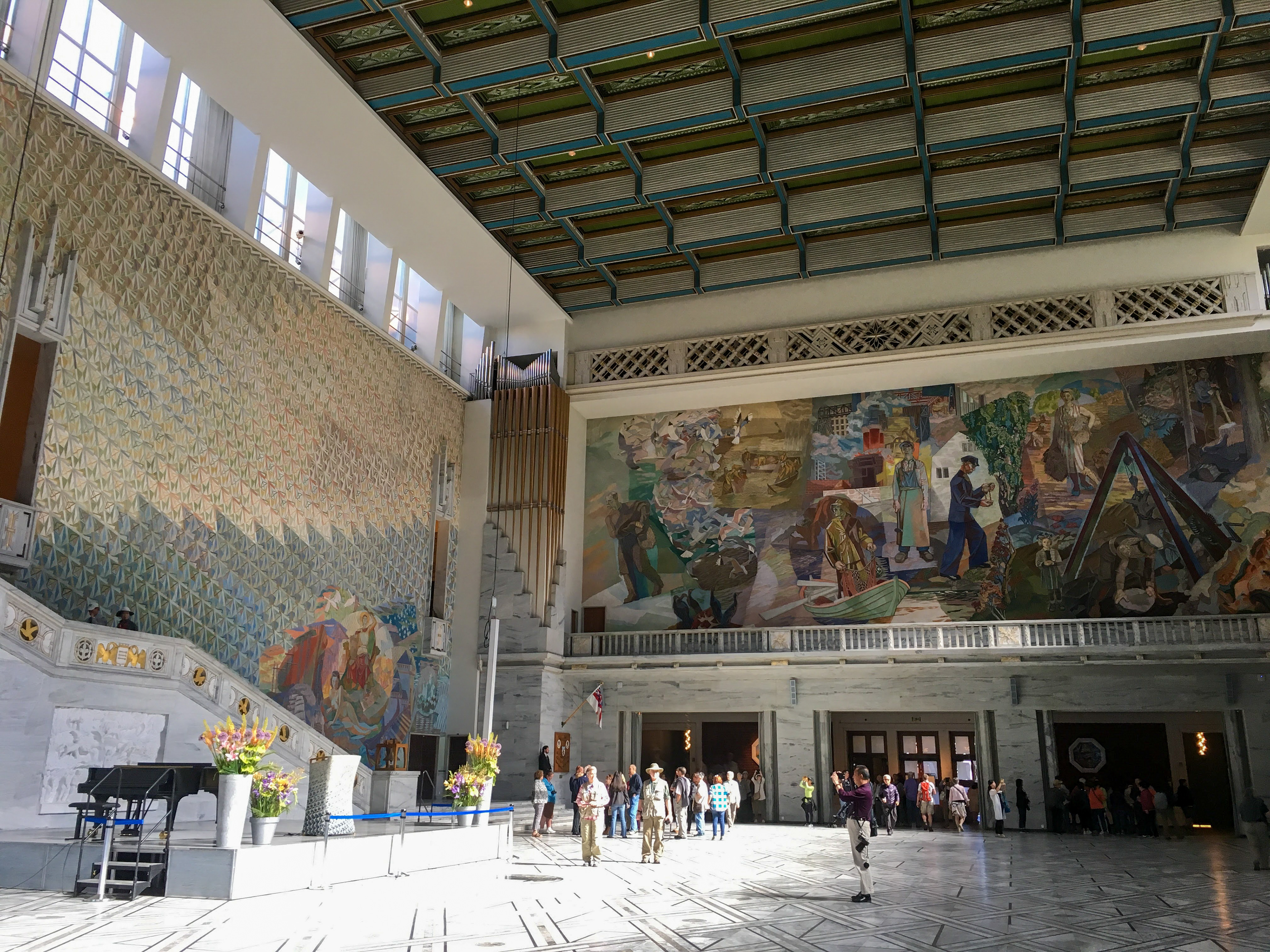 The main hall of Oslo City Hall. One wall is covered by a massive oil painting by Alf Rolfsen, titled "Arbeidets Norge fra de drivende garn til skovene i øst" ("Norwegian trade routes from the drifting nets to the forests in the east") c. 1938-1950