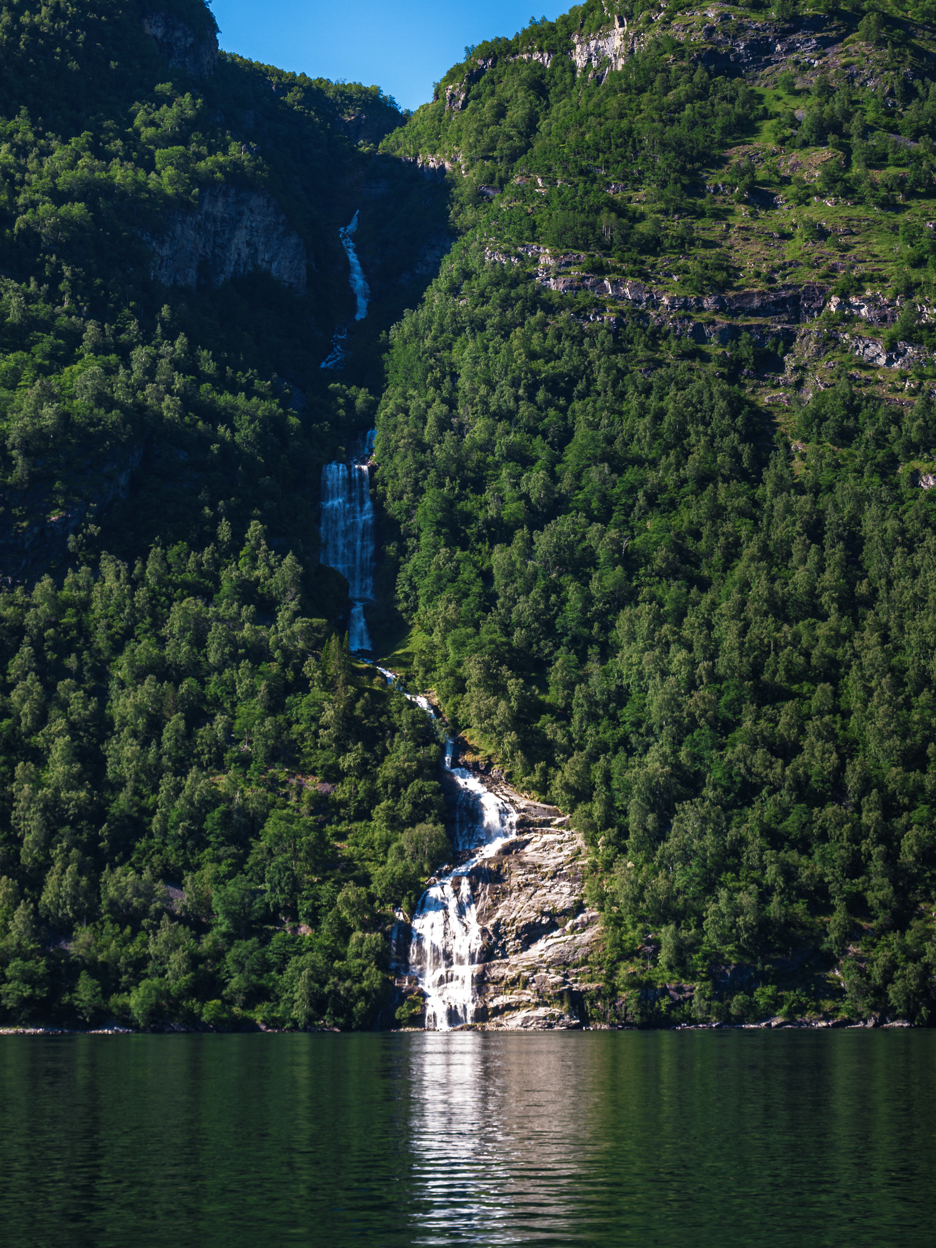 Water falls many hundreds of meters down into Geirangerfjord