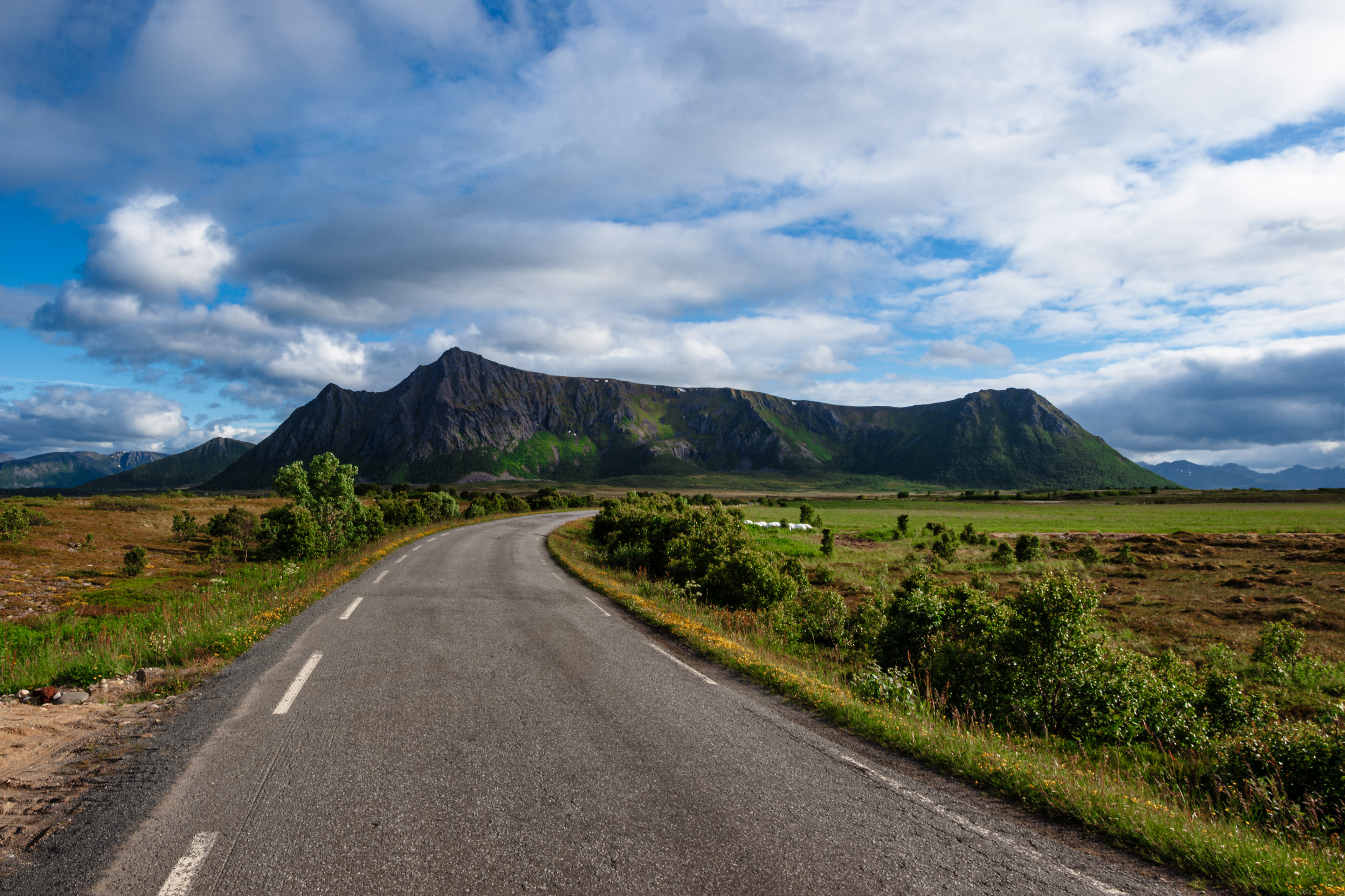A mountain with multiple peaks is visible on the road west to the tip of the Lofoten archipelago