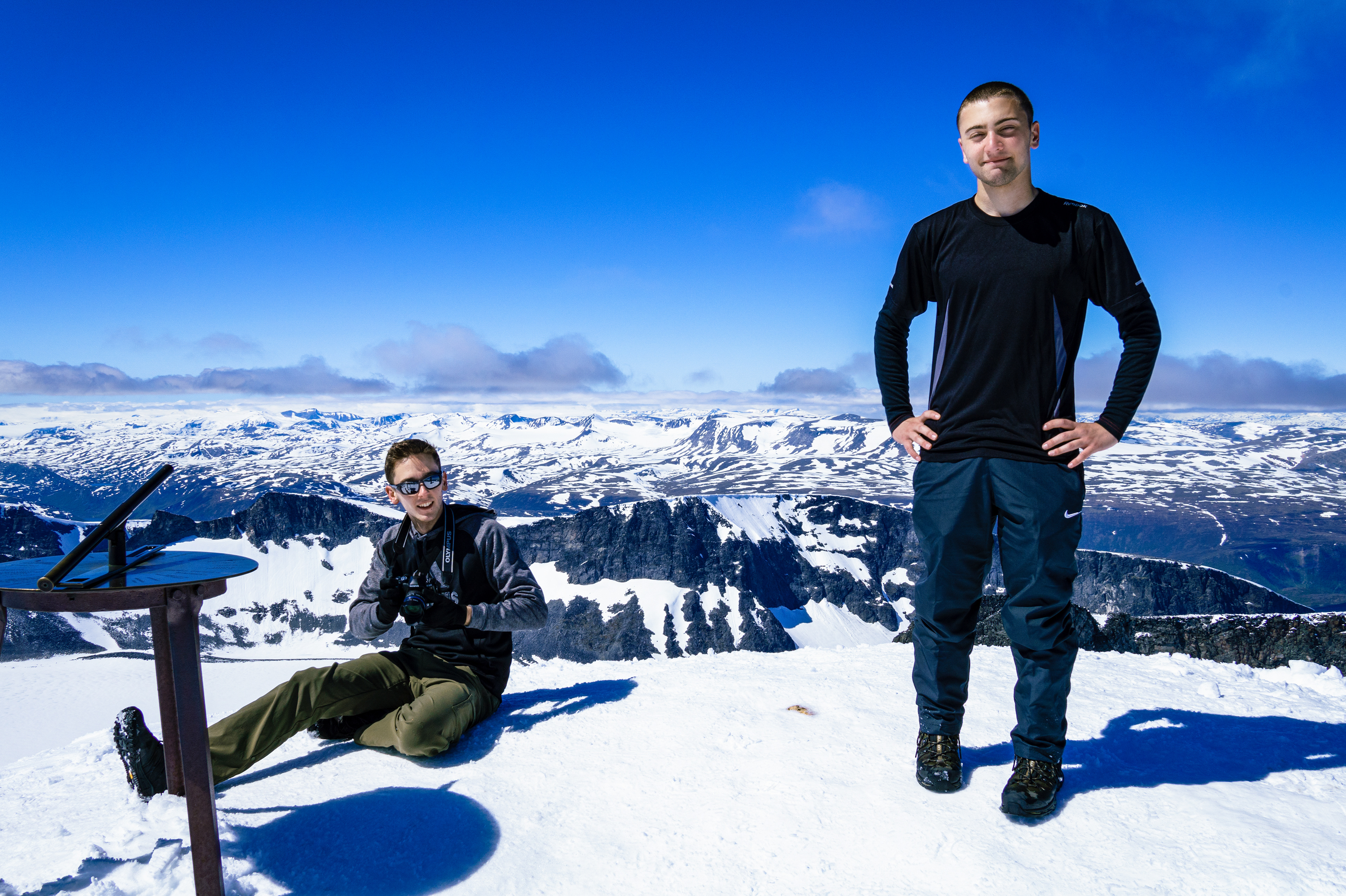 James sits to take photos from the summit of Galdhøpiggen, while Nick towers over the entirety of Northern Europe (2,469m / 8,100 ft)