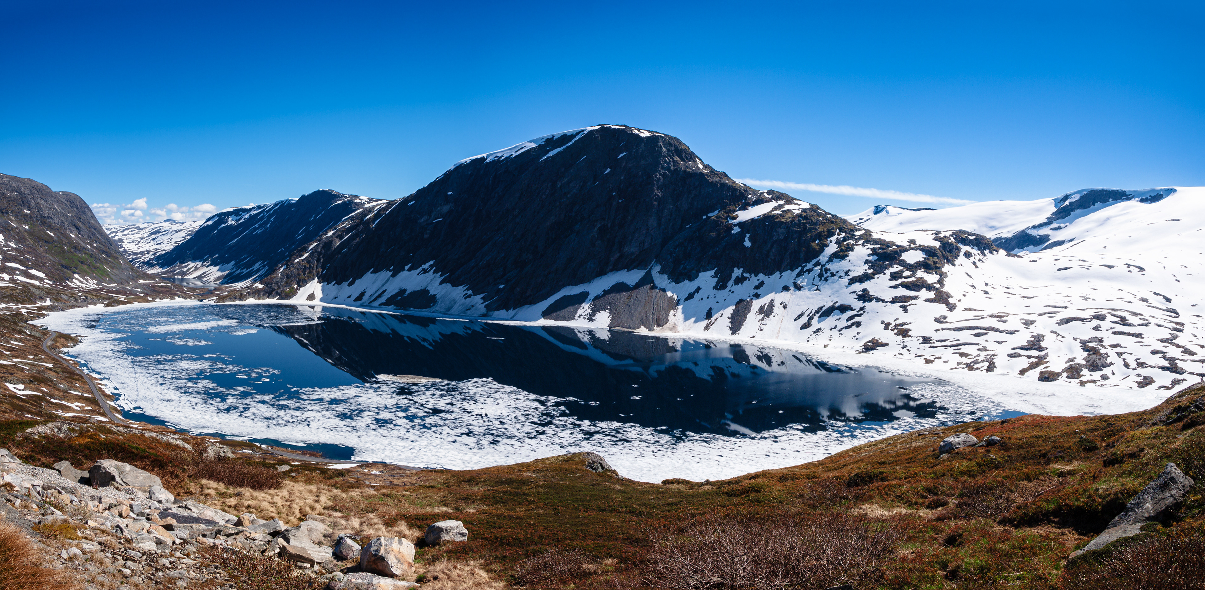 An icy lake nestled in the mountains along the steep descent into Geirangerfjord