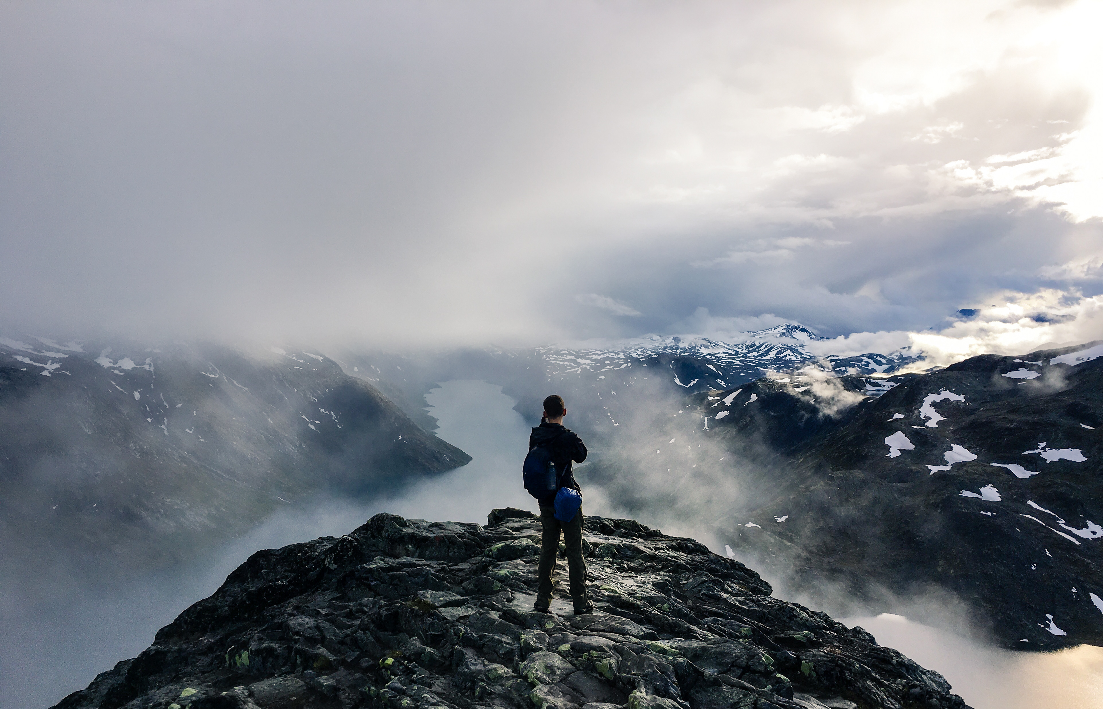 James pausing to capture a distant fjord while clouds swirl ominously