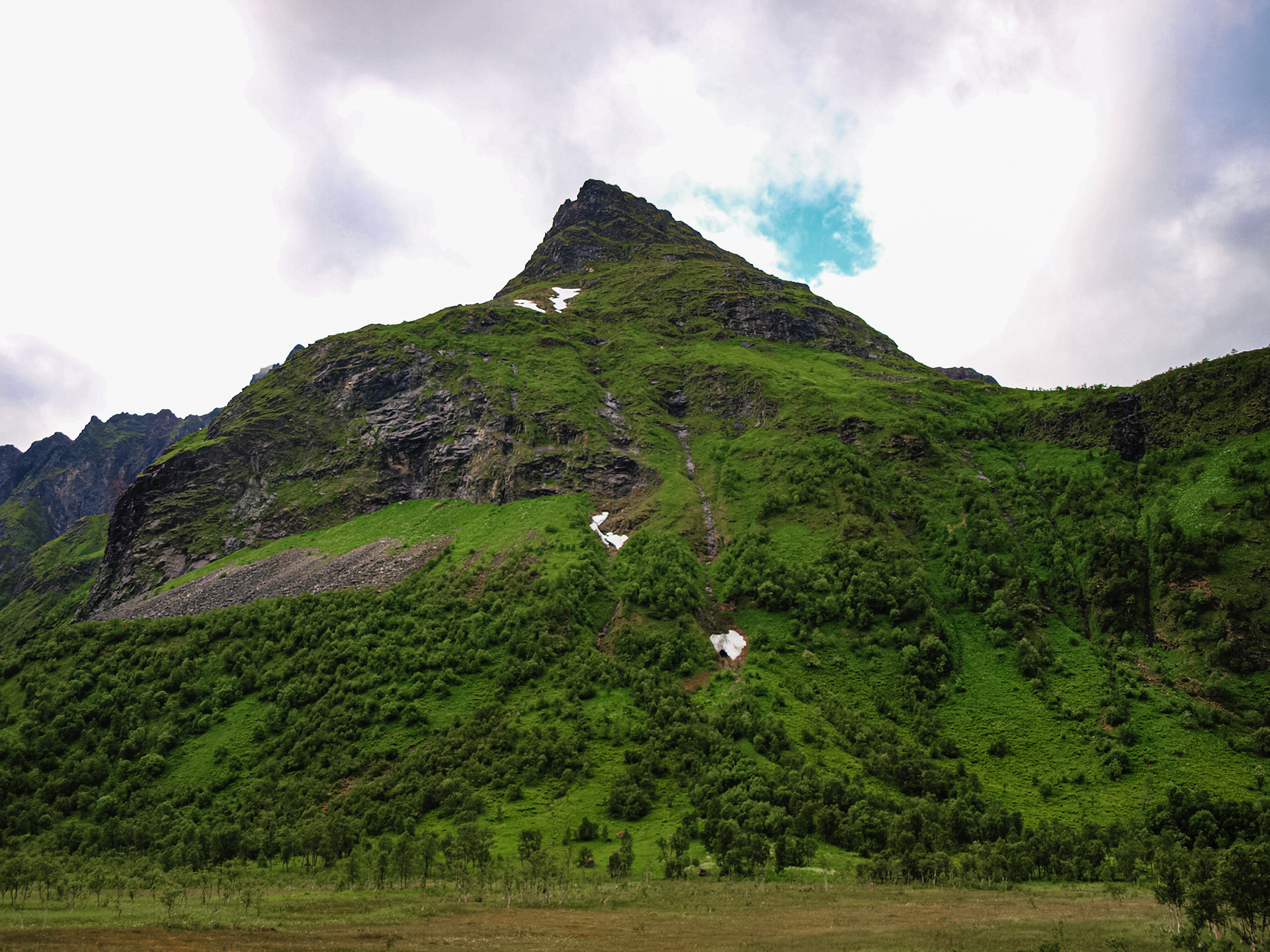 A prominent peak is visible from the winding Lofoten road