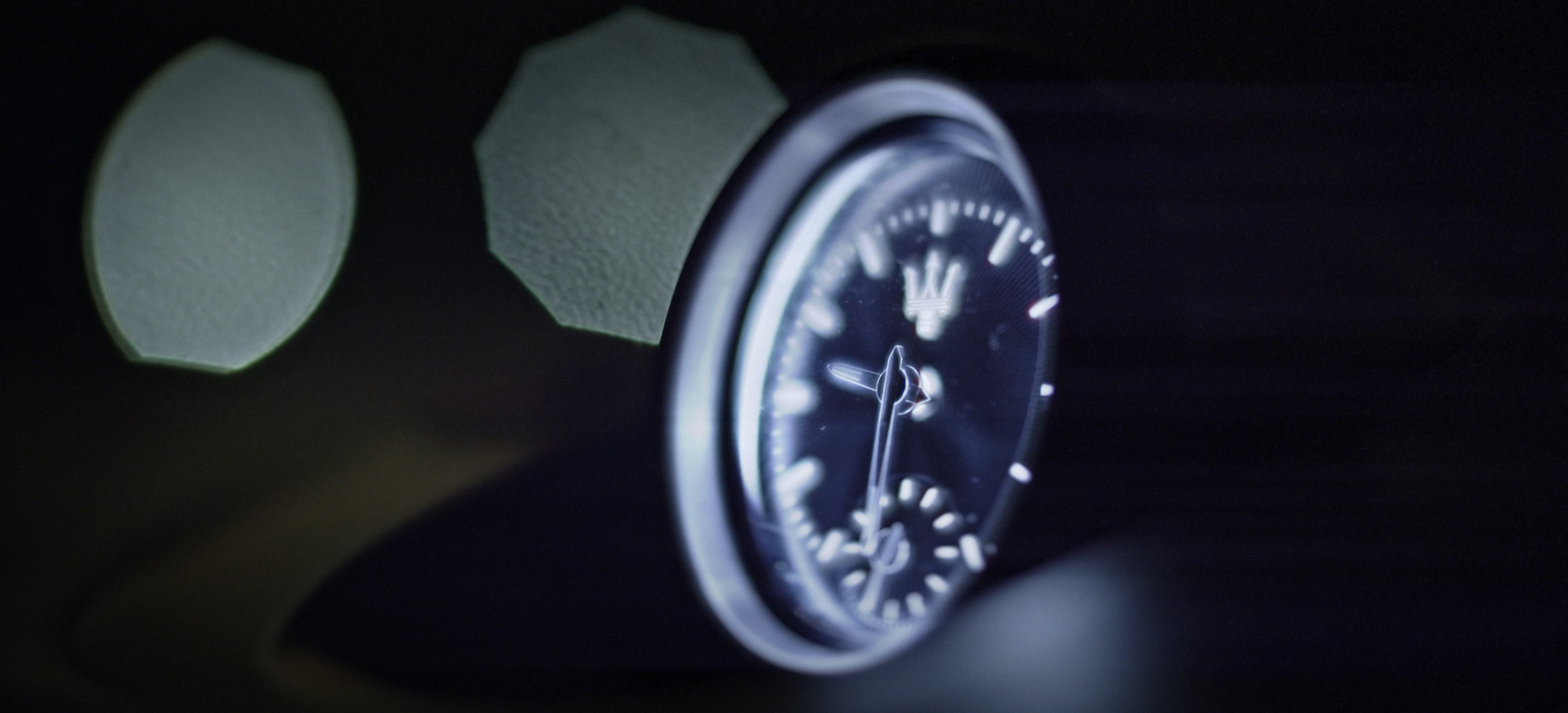 Shot of the clock on a center console at night with large bokeh balls behind it of a Maserati Levante for a commercial for 2CG Automotive Styling by Carpe Noctem Films, shot by Sam Casey