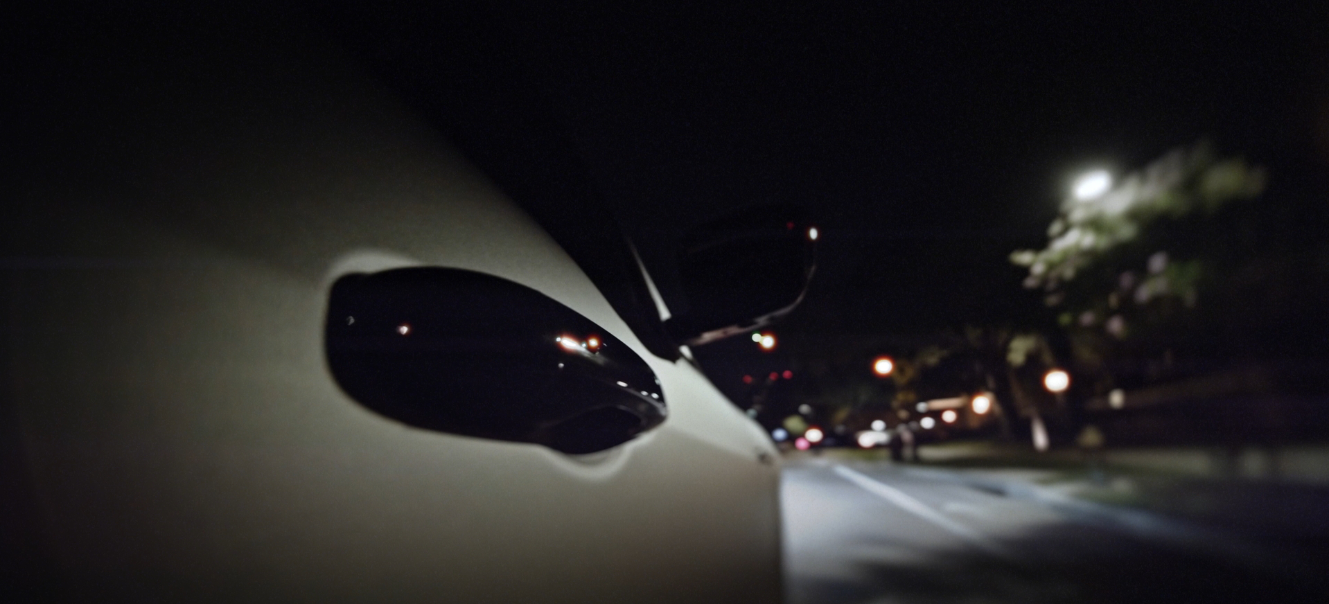 Side-mounted car mount camera shot of a door handle of a vinyl-wrapped Maserati Levante at night for commercial for 2CG Automotive Styling on a street in Dallas, Texas by Carpe Noctem Films, shot by Sam Casey