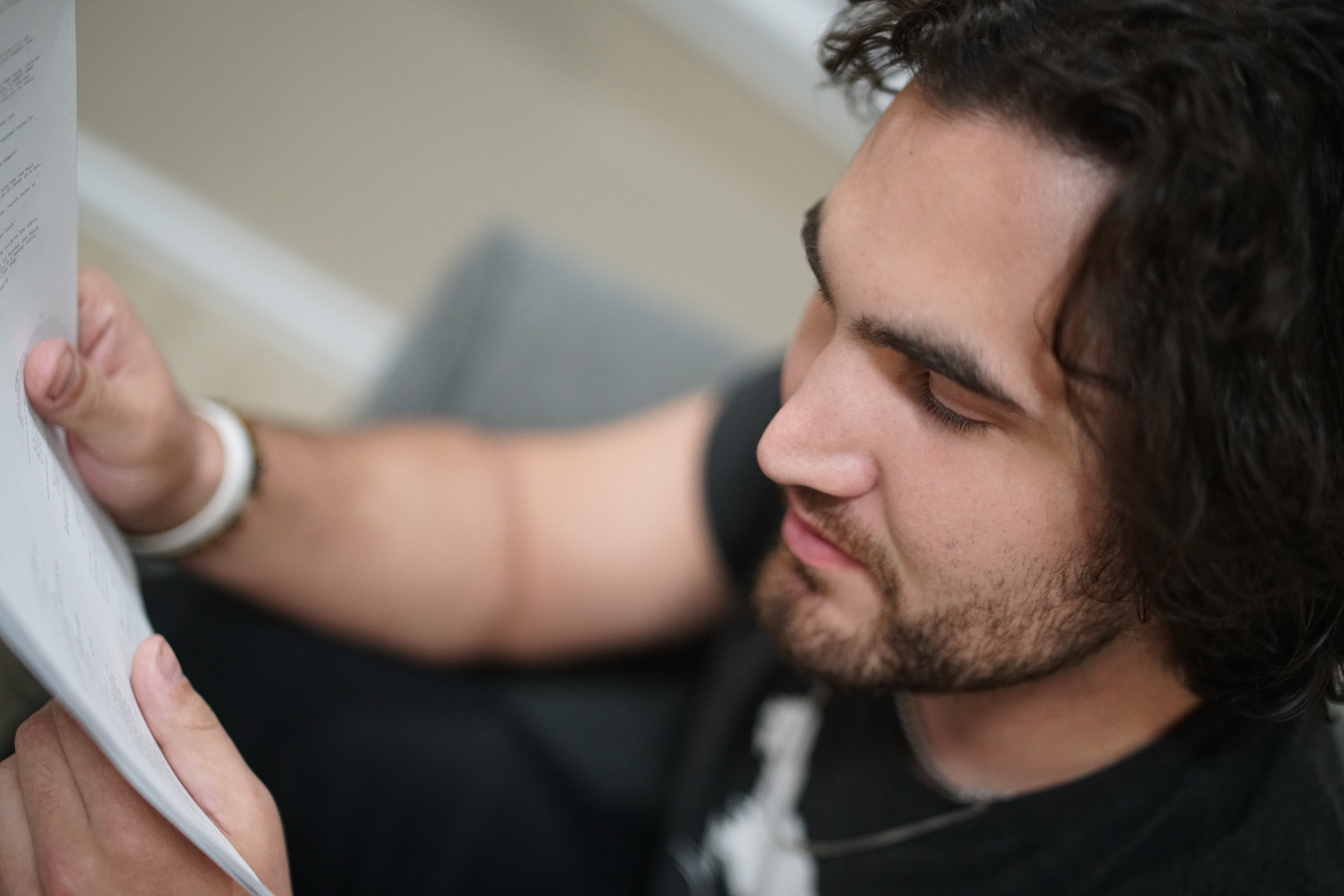 A bearded Sam Casey reading a script in 2022