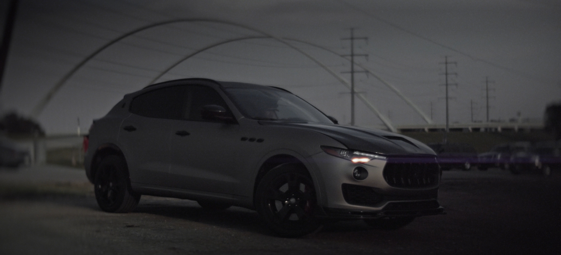 Still of a vinyl-wrapped Maserati Levante at dusk in front of the Margaret McDermott Bridge in Dallas, Texas from a commercial advertisement with cinematography by Carpe Noctem Films, shot by Sam Casey