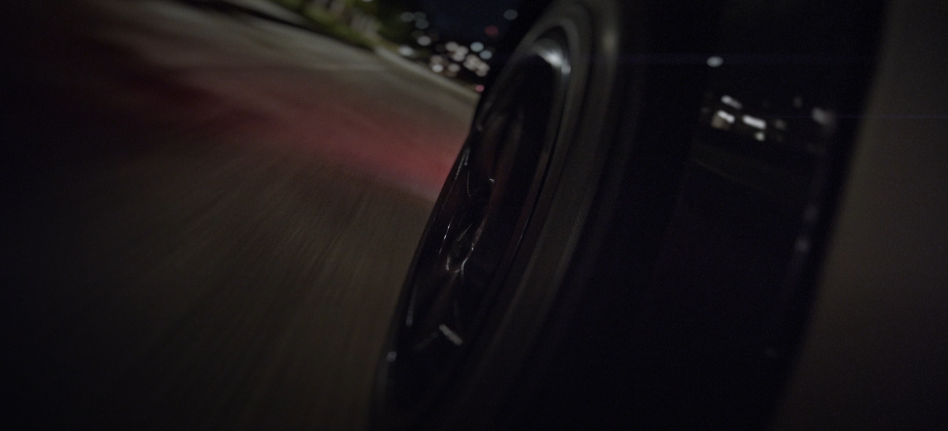 Side-mounted car mount shot of the rear right wheel of a vinyl-wrapped Maserati Levante on a Dallas street at night for a 2CG Automotive Styling commercial advertisement by Carpe Noctem Films, shot by Sam Casey