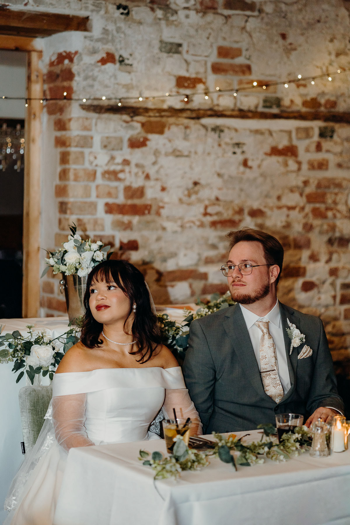 Bride and groom listening to parent's speech, by a Rotterdam wedding photographer.