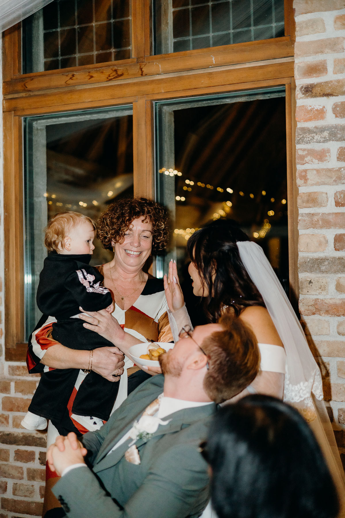 Bride and groom interacting with family members, taken by Dutch wedding photographer.