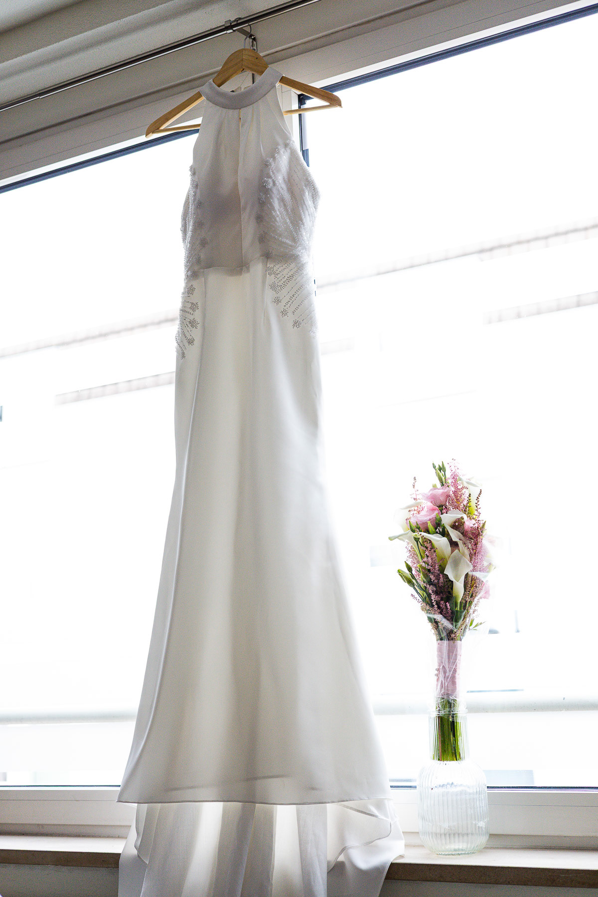 Trouwjurk en bruidsbloemen in een romantische licht.