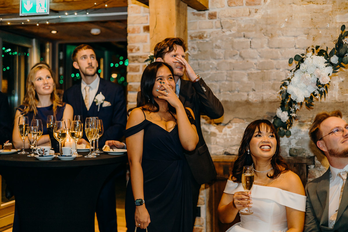 Synchronous laughs of wedding guests.